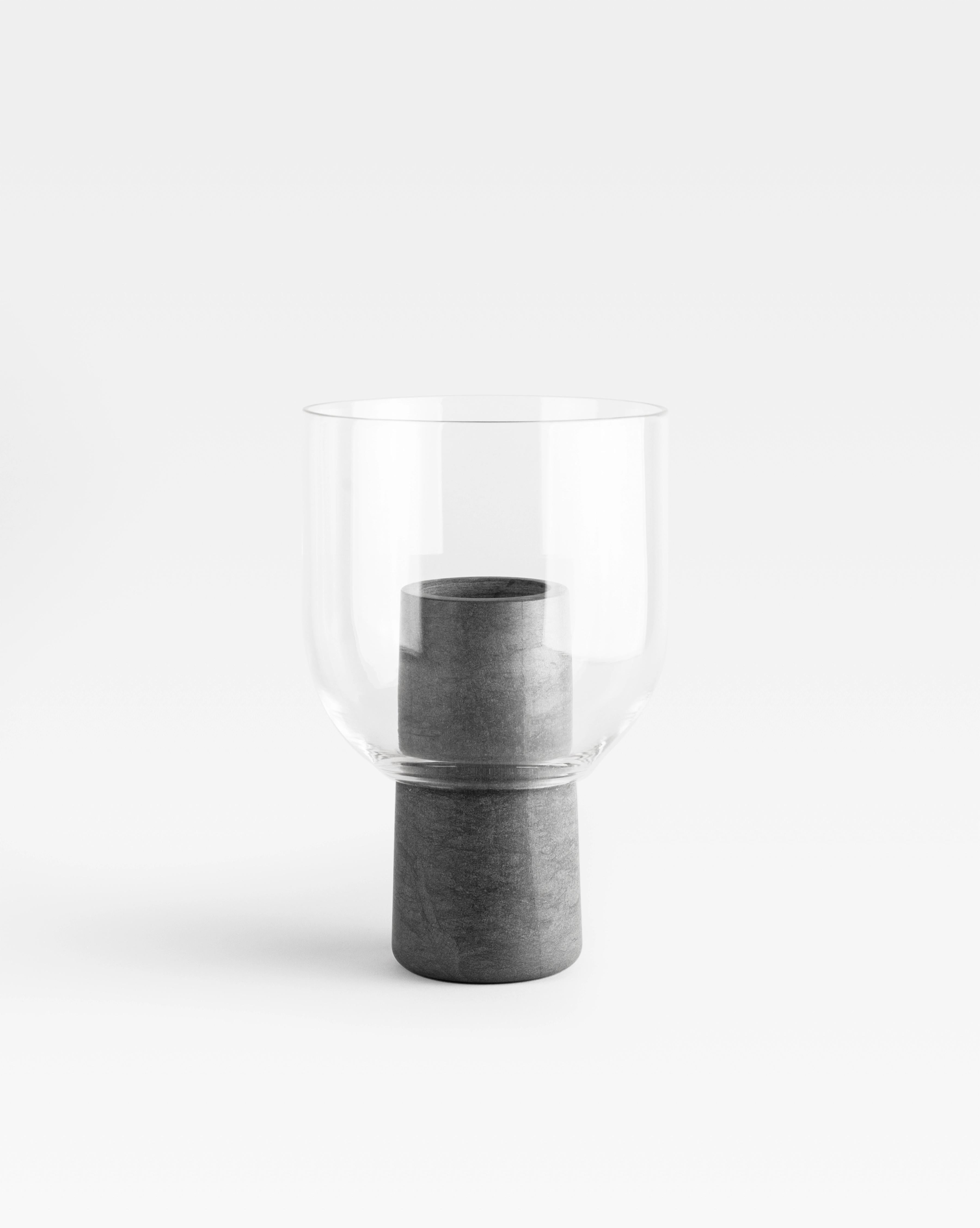 A glass and marble vase to add a touch of softness and detail to the interior. The thin and delicate material of the top contrasts the marble body of the base and creates a layered silhouette. The Italian word 