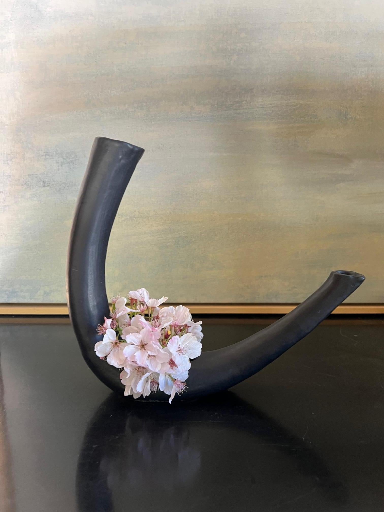 Hand made Ikebana vase, glazed in a matte black for a sophisticated look. The vase is horn shaped with a shallow hole in the bottom.