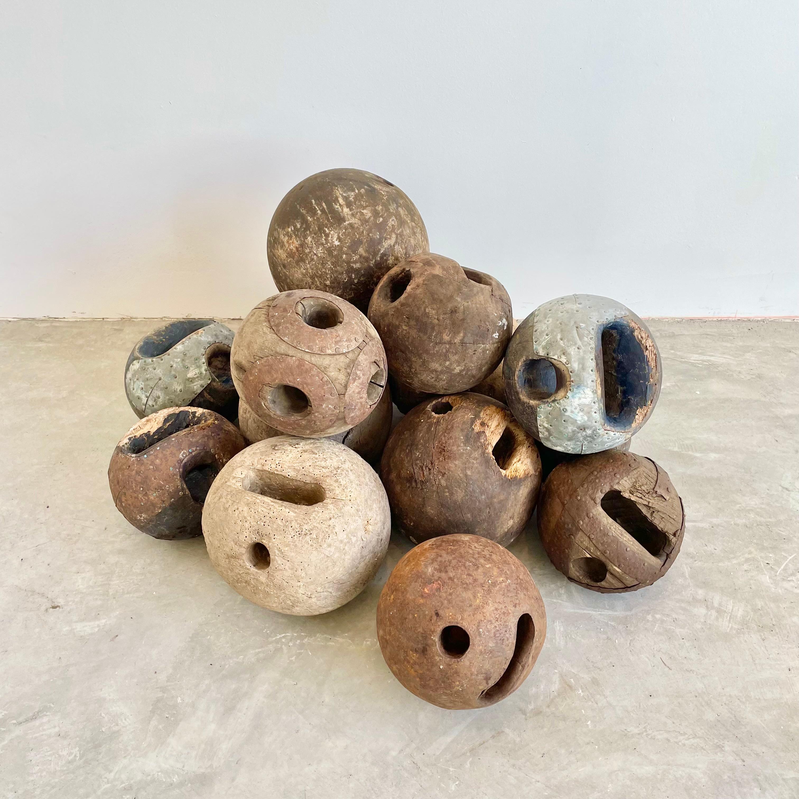 Hand made wooden bowling balls with thumb and finger grips carved out of the wood. Slightly varying size and patina for each ball as well as some being painted blue while others are in a natural wood. Amazing presence and depth that only gets better