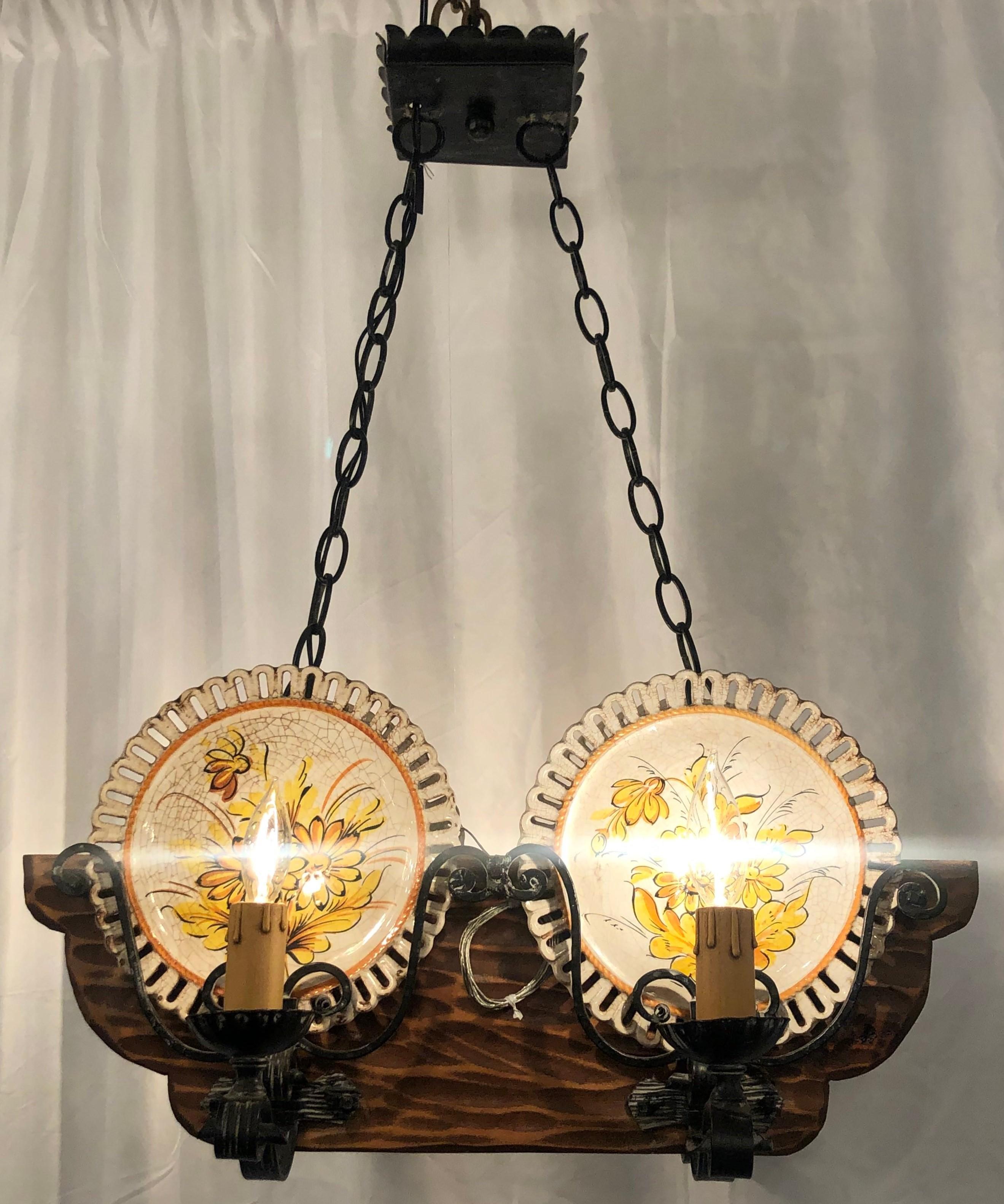 Hand-made wrought iron and carved wood porcelain plate-holder chandelier.