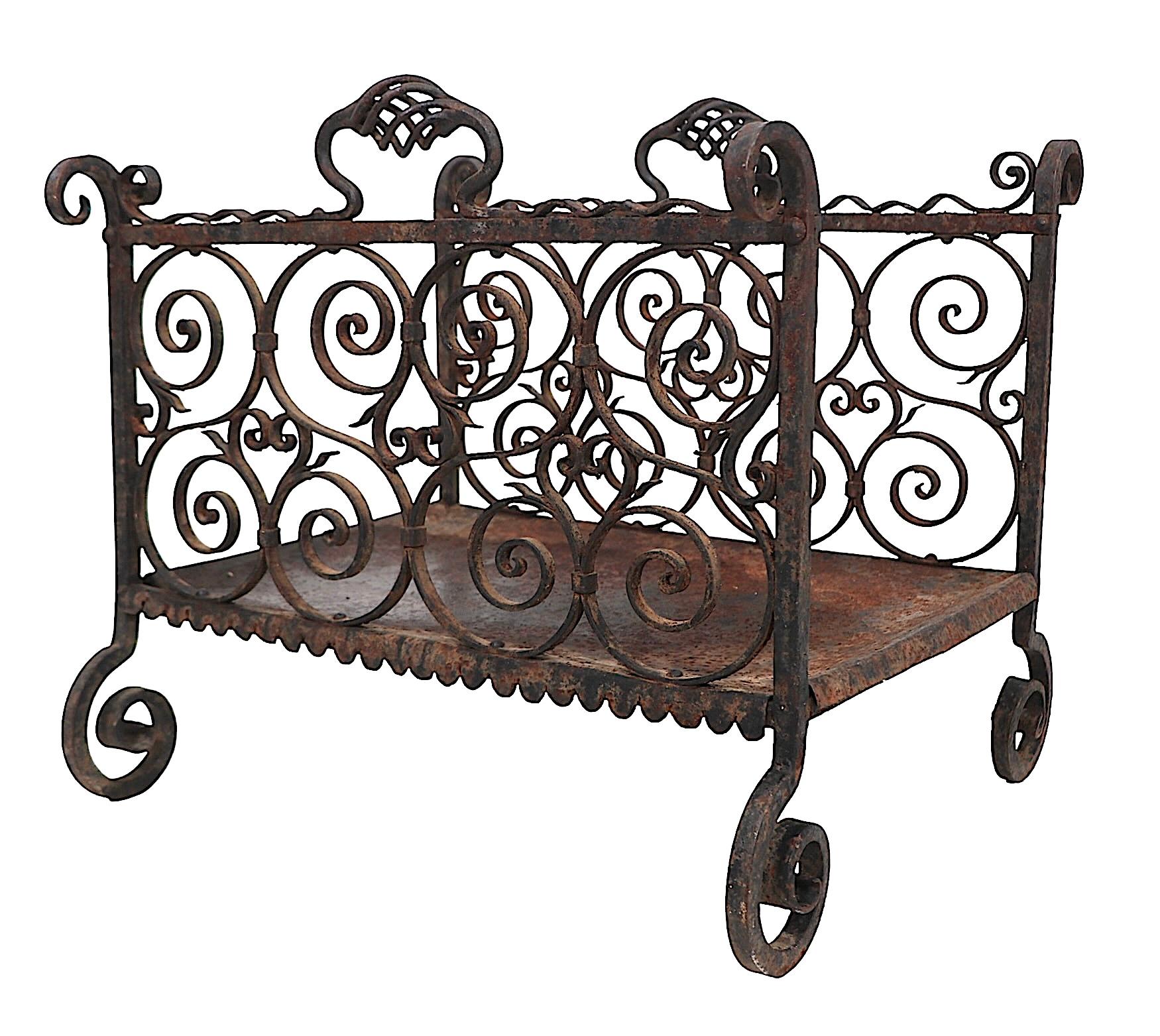 Exceptional  log holder exhibiting finely crafted intricately worked wrought iron executed in the Arts and Crafts, Mission,Gothic Revival style. We believe this example was made in the USA circa 1880/1920's it is unsigned. The log holder is in very