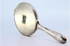 Hand mirror in embossed silver with bow and friezes around the edge