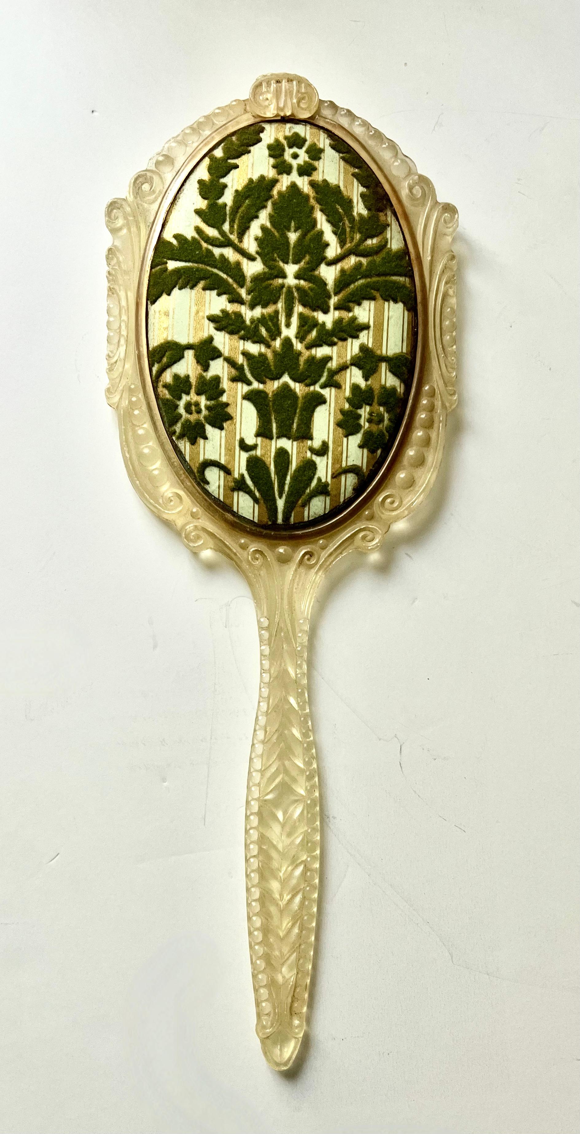 A lovely hand mirror with all the right looks, however, made of materials that aren't top quality.

The piece is made of plastic - ornate as it might be, it has yellowed a bit, but something about this mirror is quite charming... it's stood the test