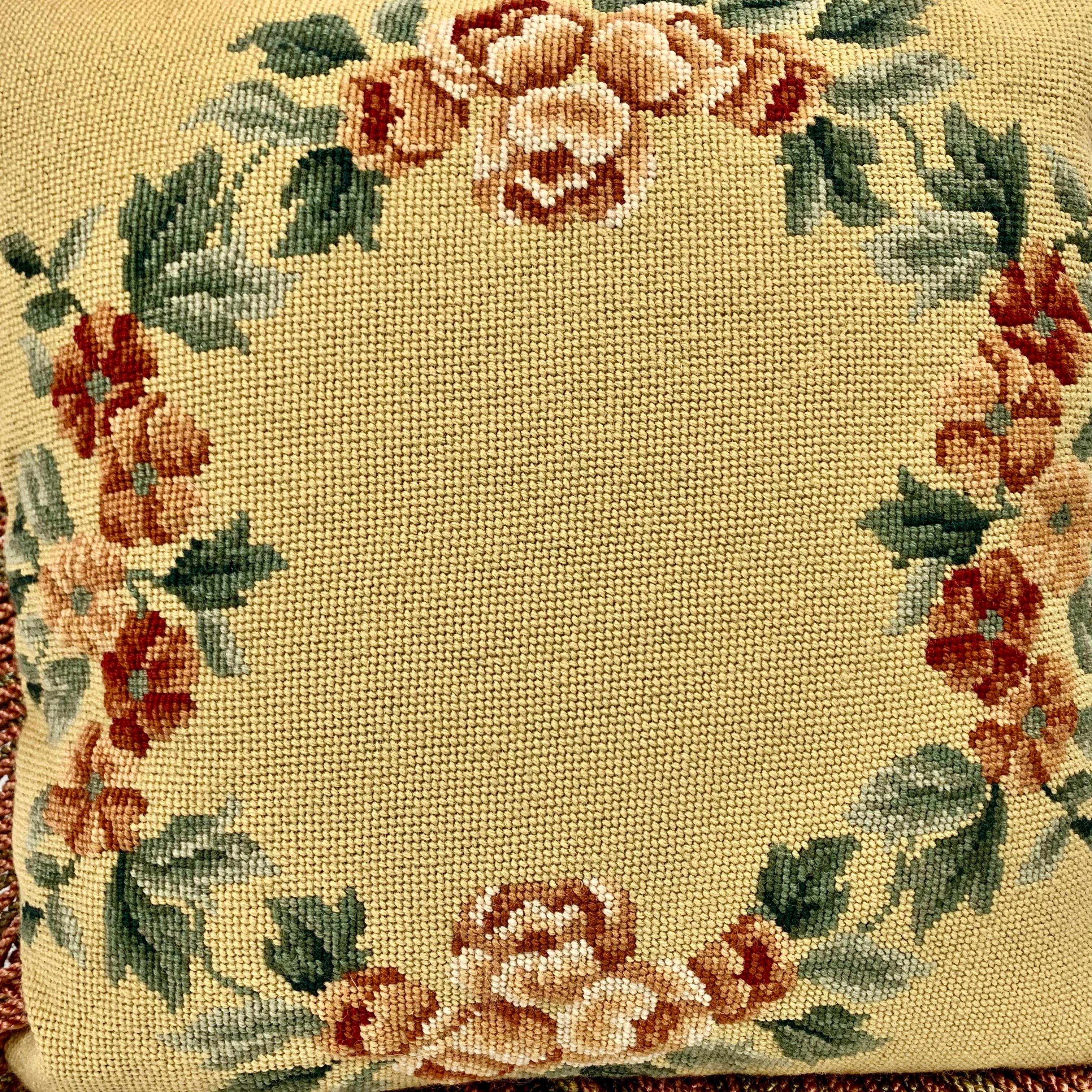 Vintage hand needlepointed cushion or decorative pillow. The design is a garland of tomato red flowers and green leaves on a golden wheat ground. The trim is fringe and the newly added backing is damask. 
Feather and down insert.
There is a blind