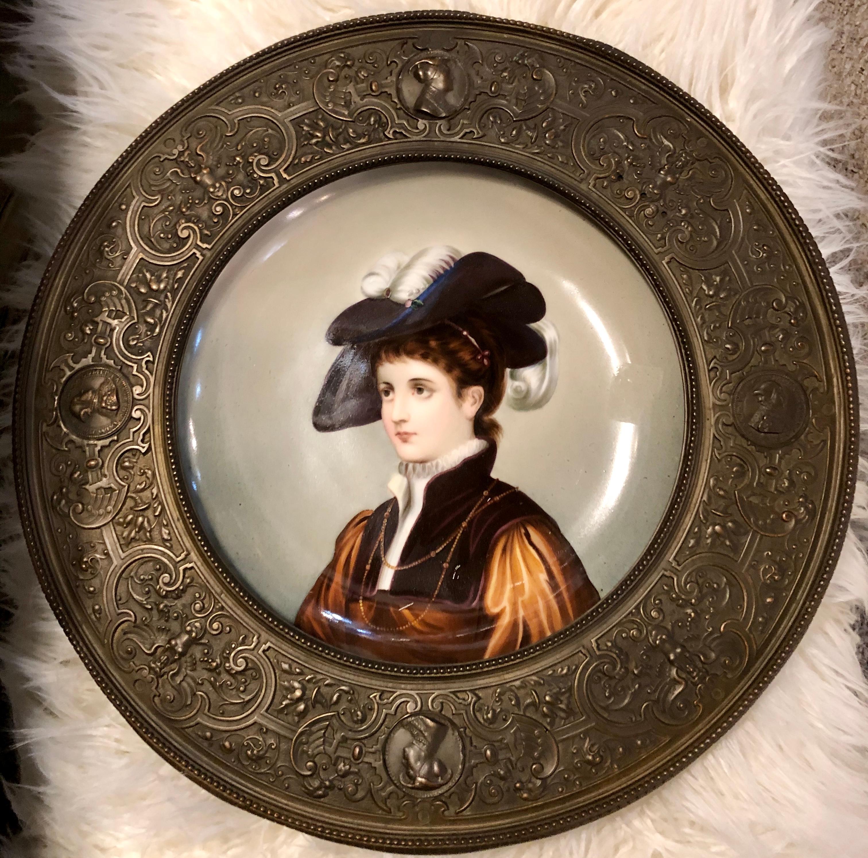 A hand painted porcelain plate framed in a high relief bronze frame. A stunning 1800s Victorian hand painted porcelain portrait with a repousse bronze frame. This alluring portrait was skillfully hand painted on a plate of porcelain. The porcelain