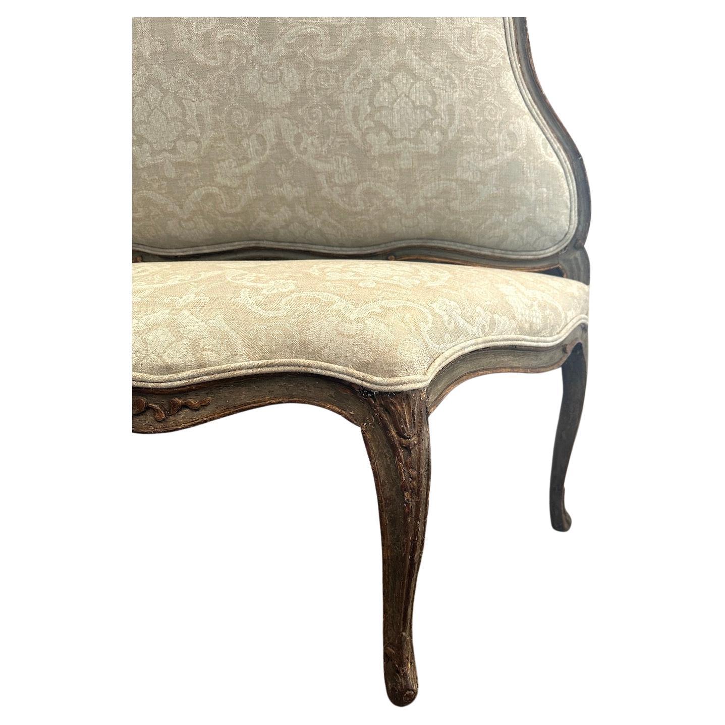Charmant banc sculpté, peint à la main et doré.  Détails floraux. Nouvellement rembourré avec une garniture couverte à double cordon.  