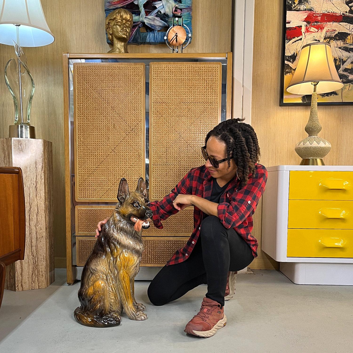 Stunningly realistic vintage German Shepherd sculpture. This exceptionally well crafted dog is rendered in terra cotta with a beautiful hand-painted and glazed finish. The radiant dog flashes a friendly grin with his tongue dangling. It’s as if he’s