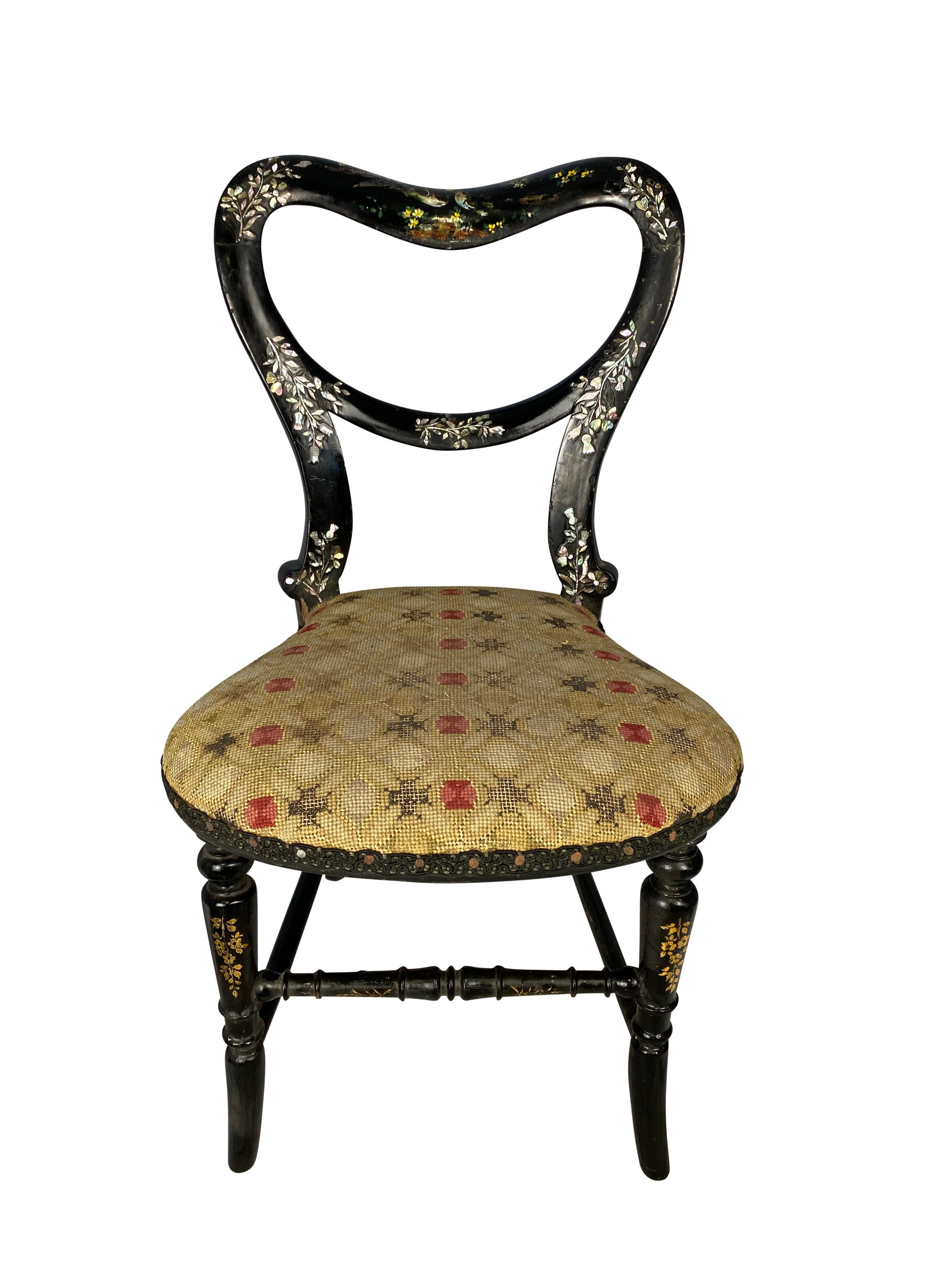 A very fine 19th century ebonized wooden miniature chair. The mother of pearl inlay and hand painted decoration of painted birds with floral surroundings all-over the frame and is accompanied by stretcher base. The inlay projects a variety of unique