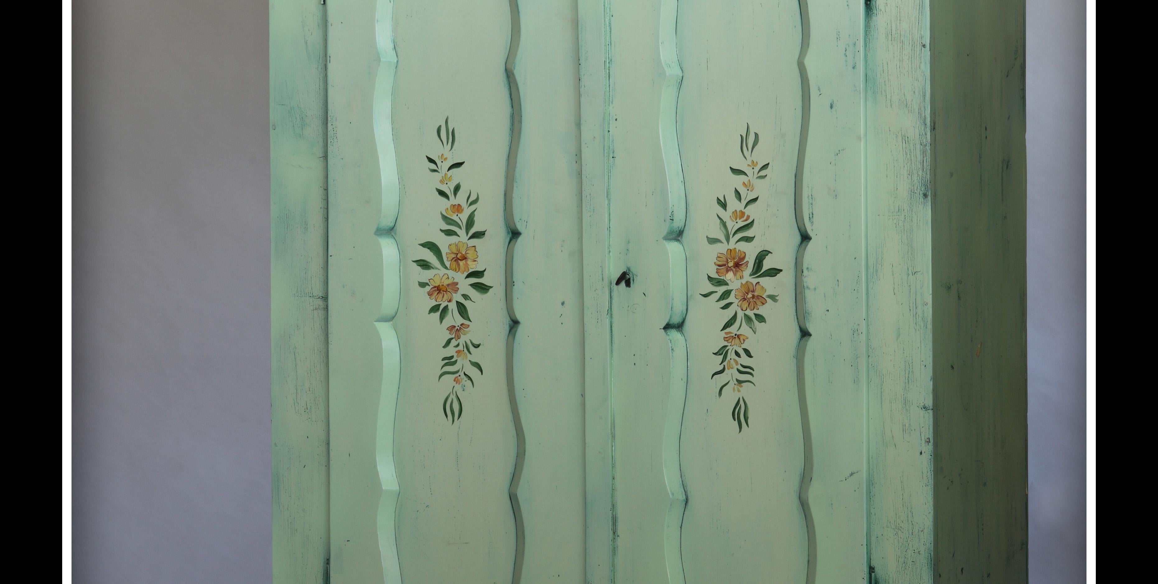 Green cabinet with flower patter, hand painted
The two doors cabinet has special surface, thanks to the antique effect painting. On
the doors are flower paintings by an artist. The intimate, folksy cabinet looks good in
bedrooms, or farmhouses,