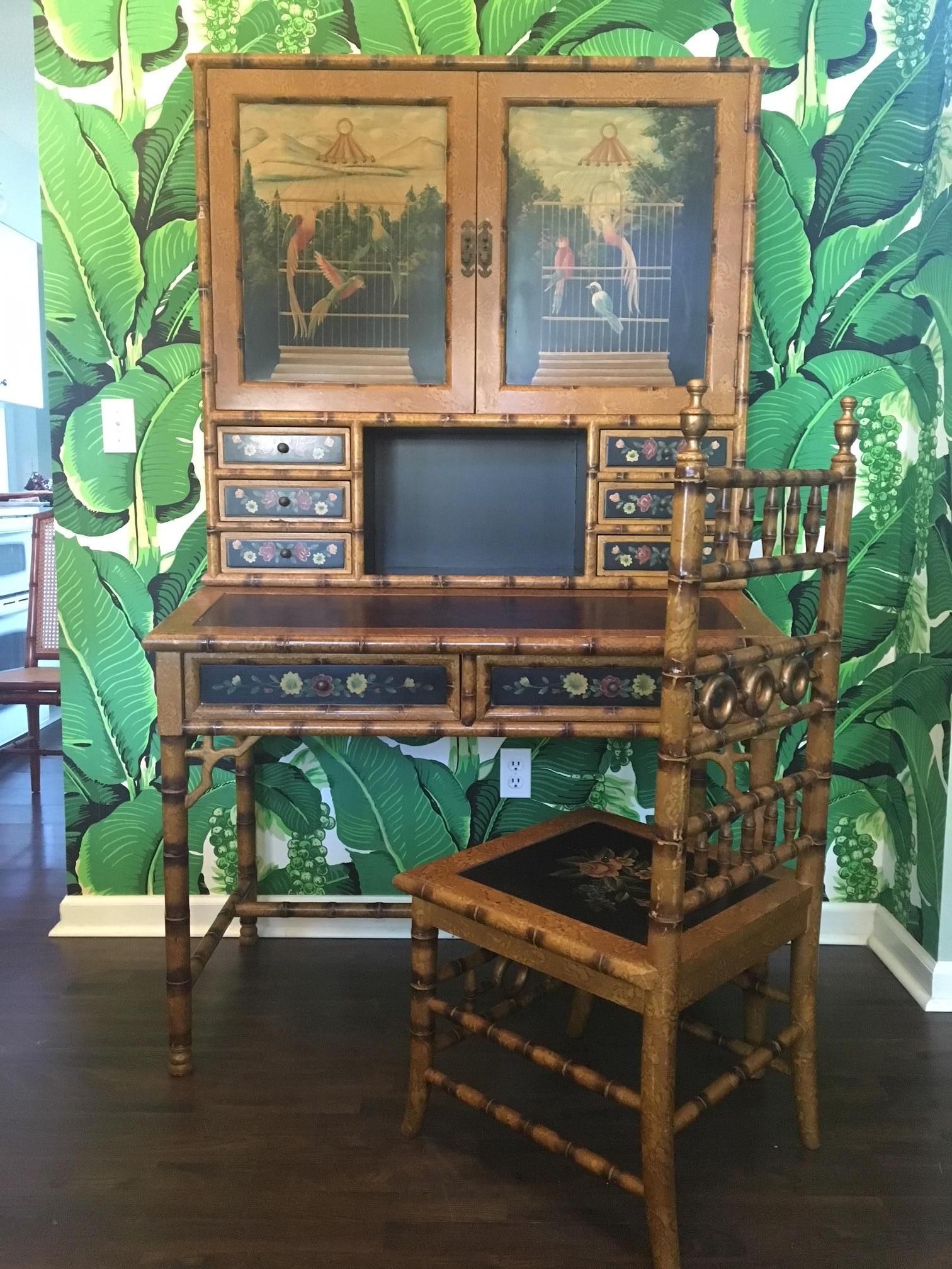 Asian chinoiserie faux bamboo desk with hutch and matching chair features hand painted tropical motif. Leather embossed desk top and bronze hardware. Desk and hutch are two separate pieces. All pieces in good condition with minor cosmetic issues