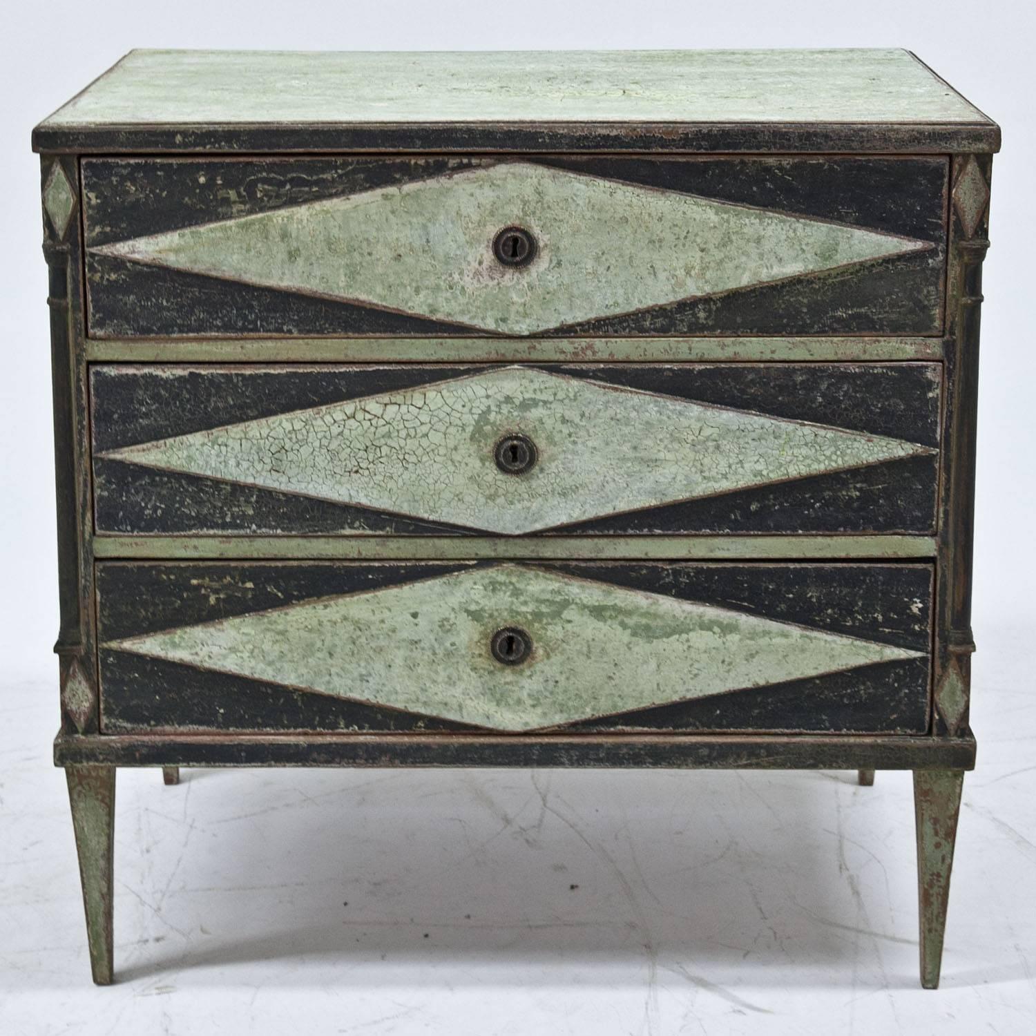 Chest of drawers on tapered legs with three drawers and a mint-green and black paint. The paint was redone and has a worn look to it.
