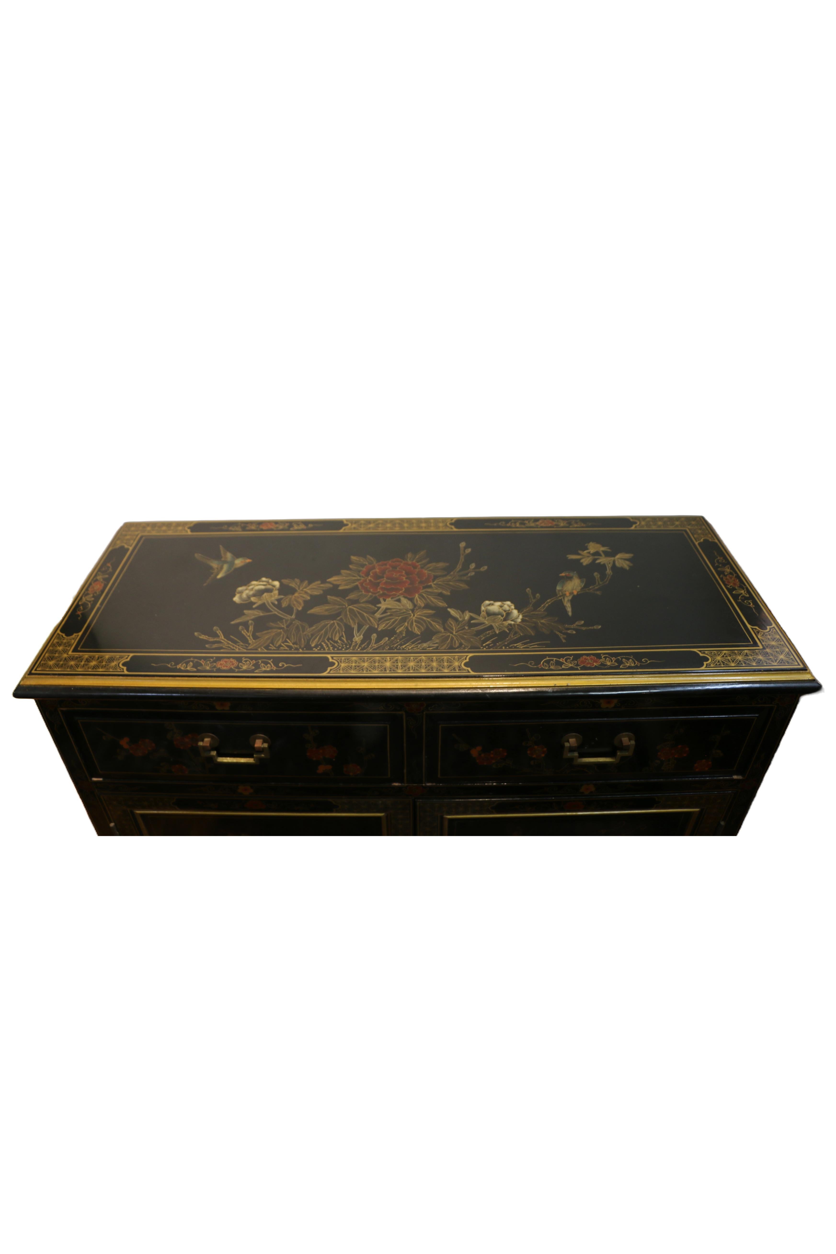 A mid century hand painted black wood chinese chinoiserie credenza with decorations. Made in the 1970s. Credenza has 2 drawers with brass handles and a cabinet on the bottom. Credenza has a glass top and one glass shelf in the cabinet underneath.