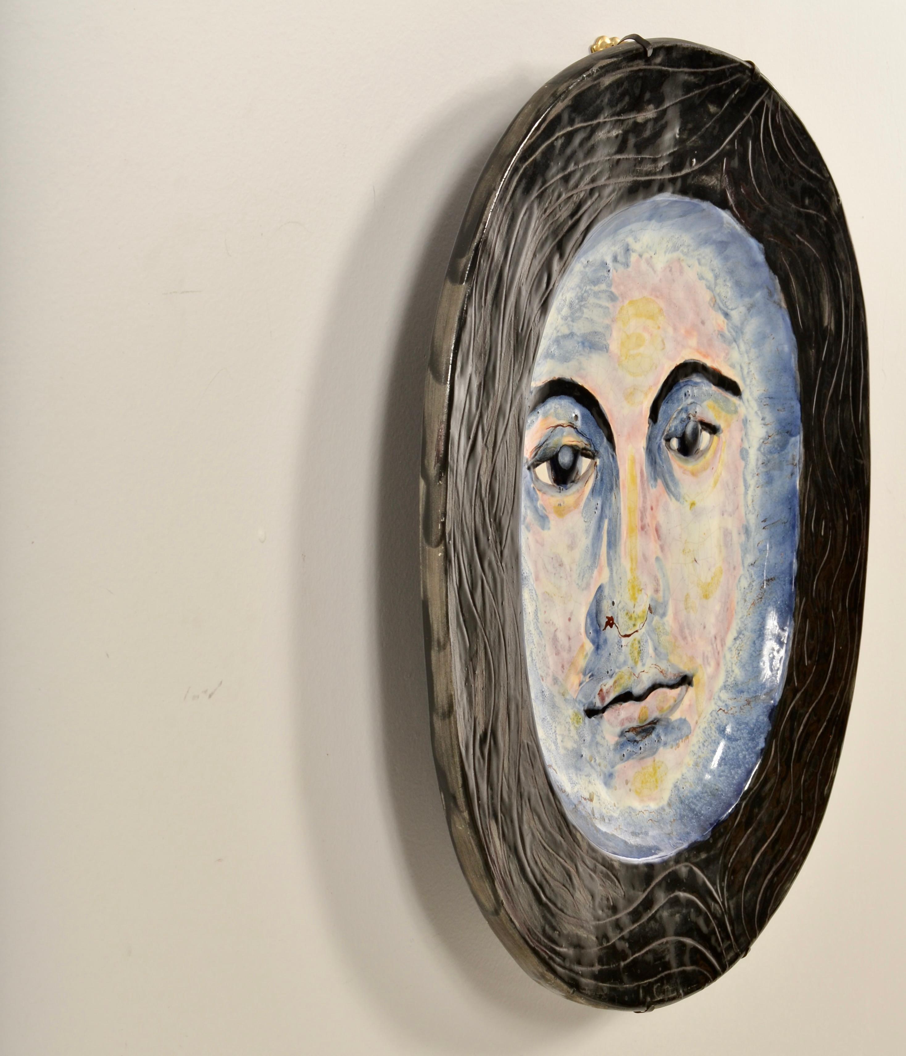 Cette œuvre en céramique signée présente un visage magnifiquement rendu avec une belle utilisation des couleurs. Finition émaillée avec une signature imprimée, que nous ne pouvons malheureusement pas déchiffrer car l'artiste est manifestement très