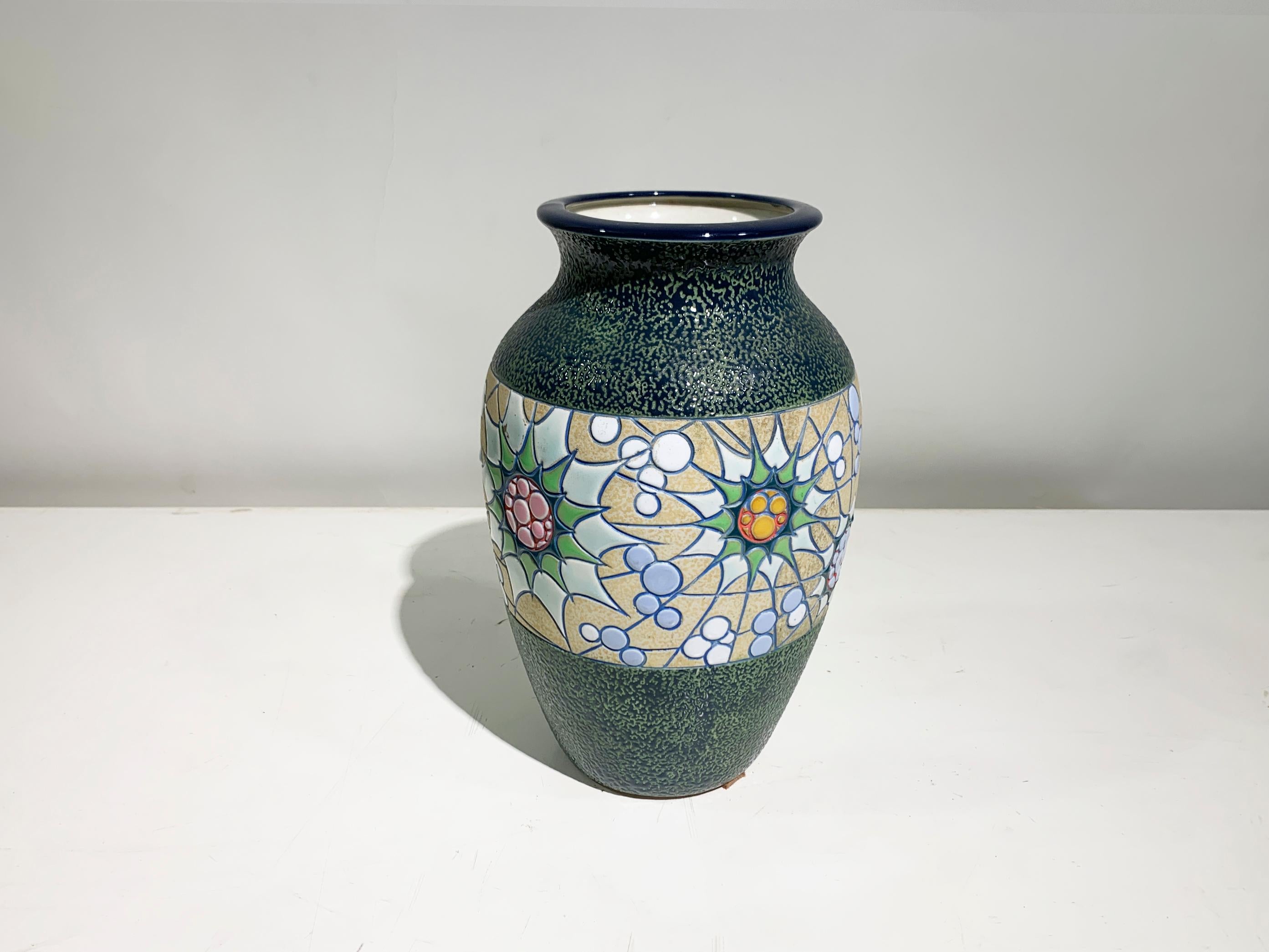 e vase en céramique peint à la main est un mélange harmonieux d'art et d'artisanat. La pièce est ornée d'un motif floral méticuleusement détaillé qui entoure sa partie centrale, offrant un contraste saisissant avec le fond texturé vert foncé qui