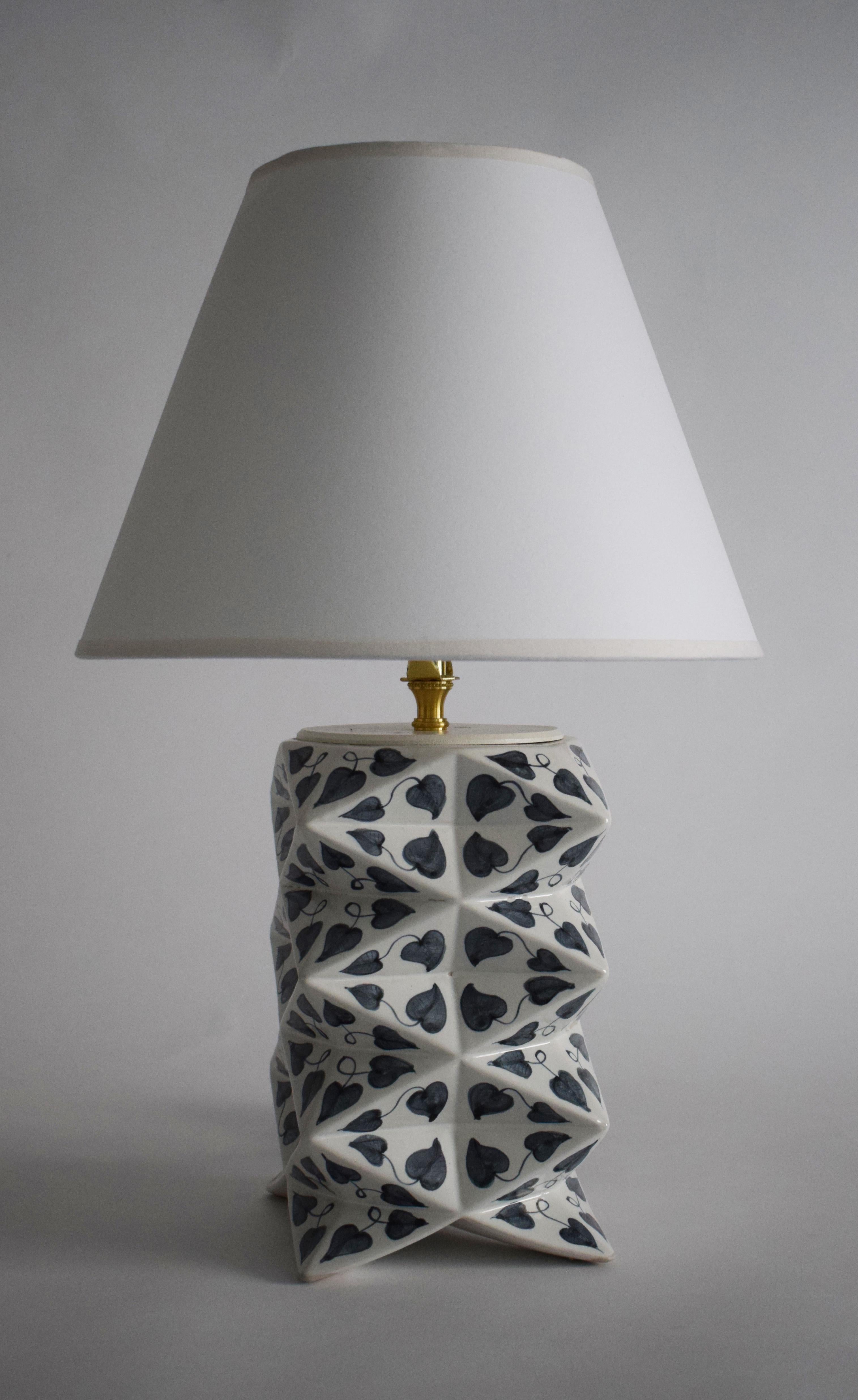 A hand-painted ceramic table lamp meticulously crafted in Vietnam to the specifications of James Hicks. This lamp harmoniously blends modern 3D form with the Vietnamese tradition of hand-painted ceramics, representing a fusion of diverse cultural