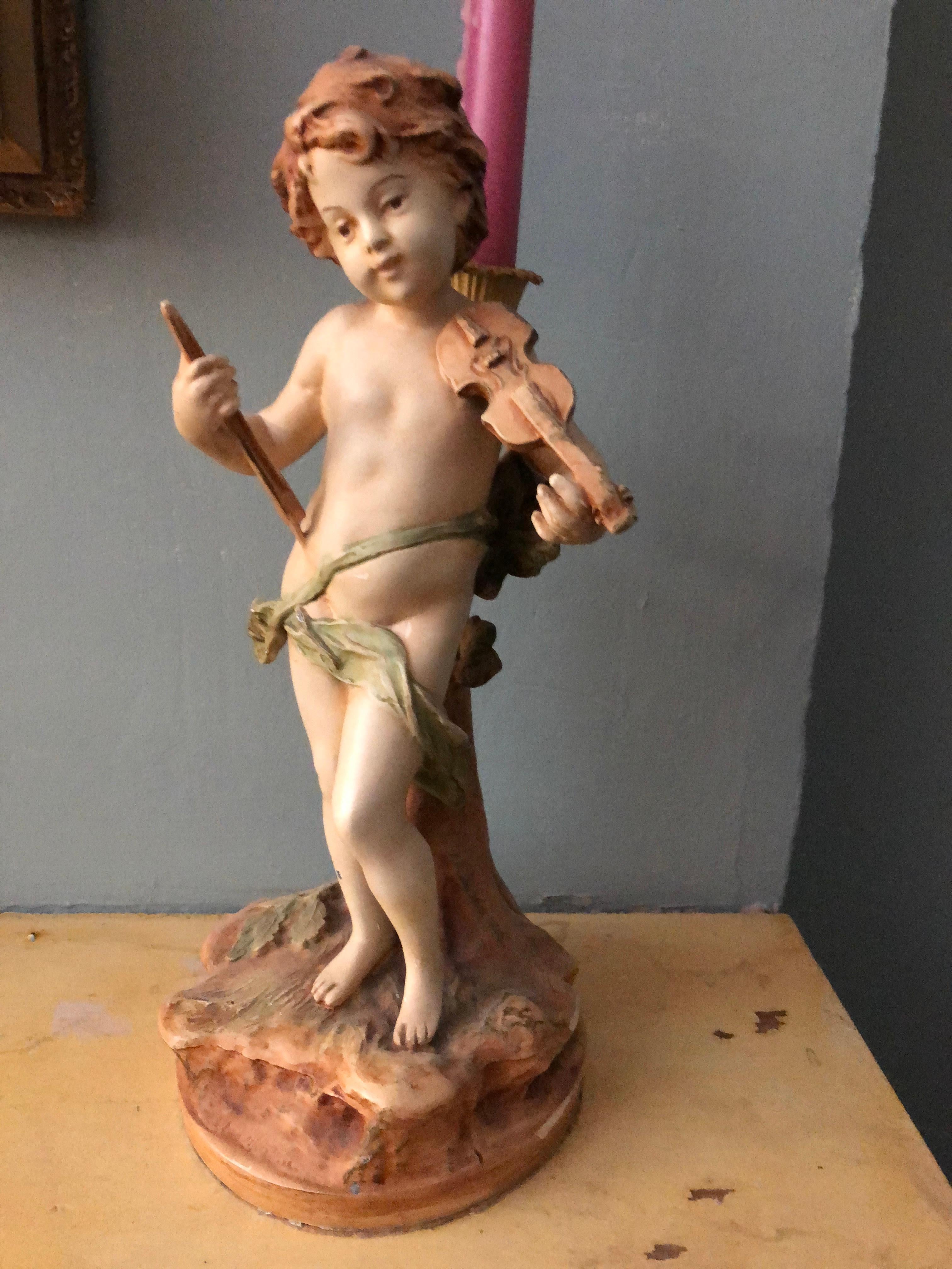 This charming vintage piece features a hand-painted cherub holding a violin and bow. Beautiful as a sculpture it also holds a candle.