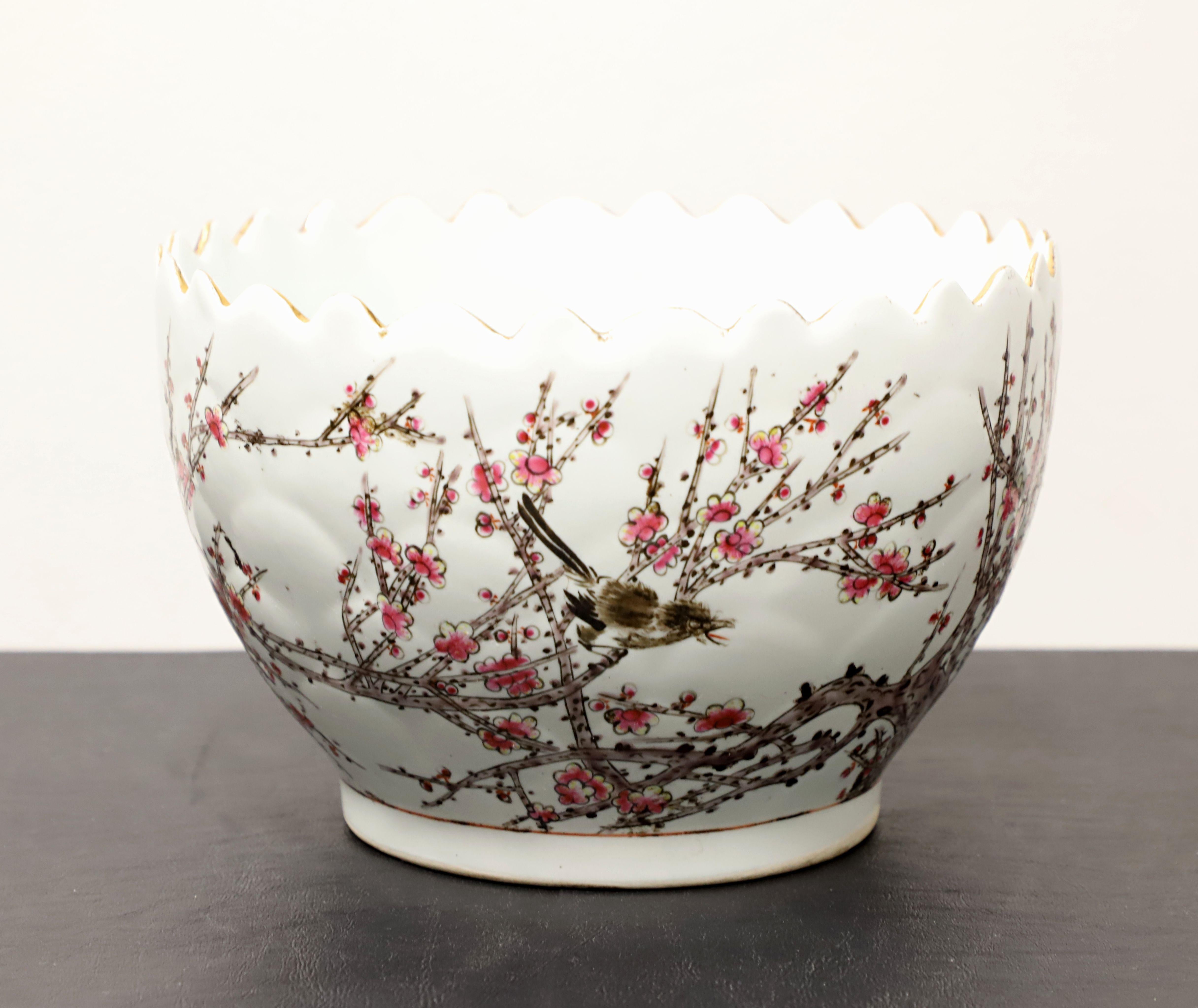 A Mid 20th Century Asian Chinese style decorative porcelain bowl, unbranded. A beautiful round porcelain bowl with a sawtooth cut edge, white color base, hand painted with cherry blossoms & birds in shades of pink, brown & black, gold accents, and