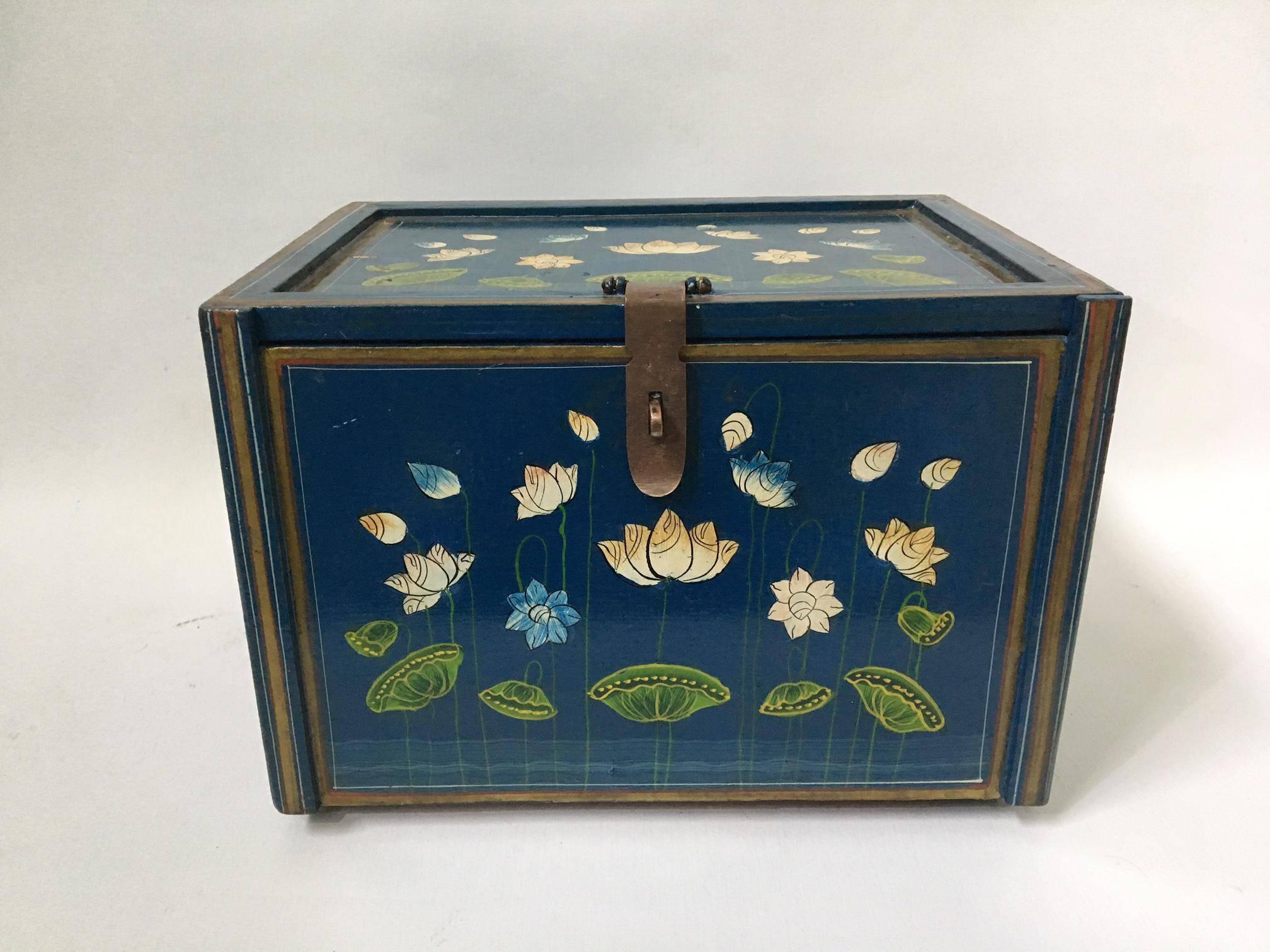 Hand-painted vintage keepsake box or jewelry box. Blue lacquer finish adorned with lily pads and blooming lotus flowers.
Interior mirror on lid when opened. Many carved compartments for all small your treasures.
Good vintage condition with some