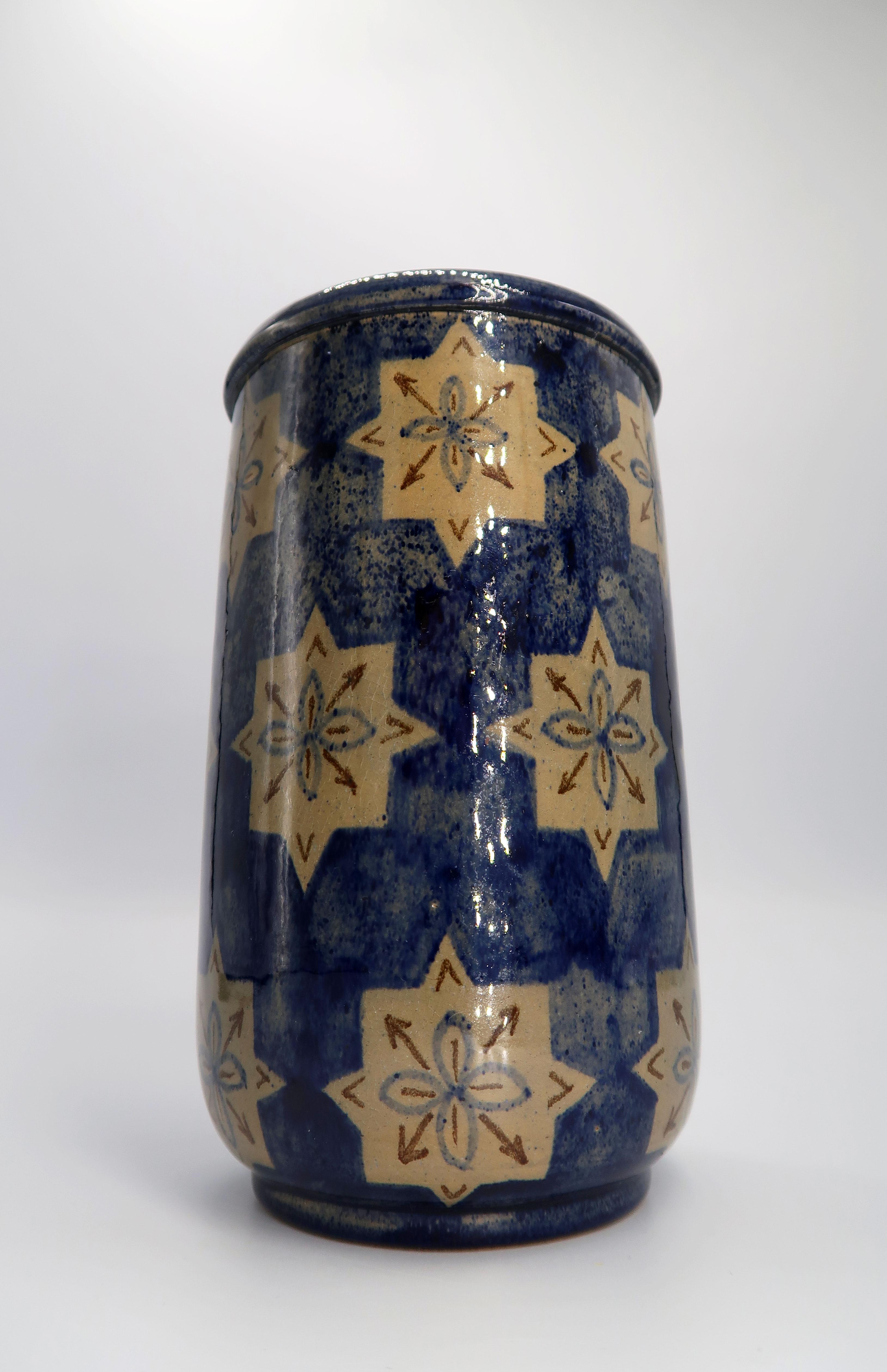 Beautiful Folk Art style Danish Mid-Century Modern handmade and hand painted ceramic vase from the early 1940s. Manufactured on the island of Bornholm by Søholm Keramik. Camel colored graphic star shapes with brown arrows on a dark blue, visibly
