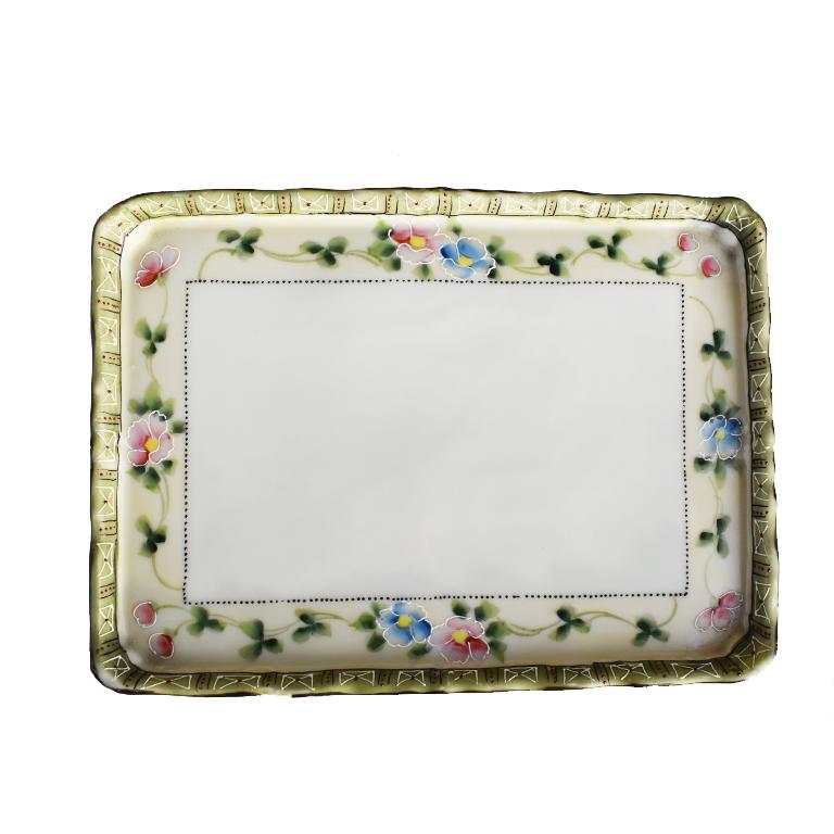 Beautiful floral ceramic rectangular porcelain tray or vide poche. This beautiful feminine ceramic tray has lovely scalloped or pie crust edges accented with a gold rim. A hand painted border of a green and white pattern is a lovely addition to the