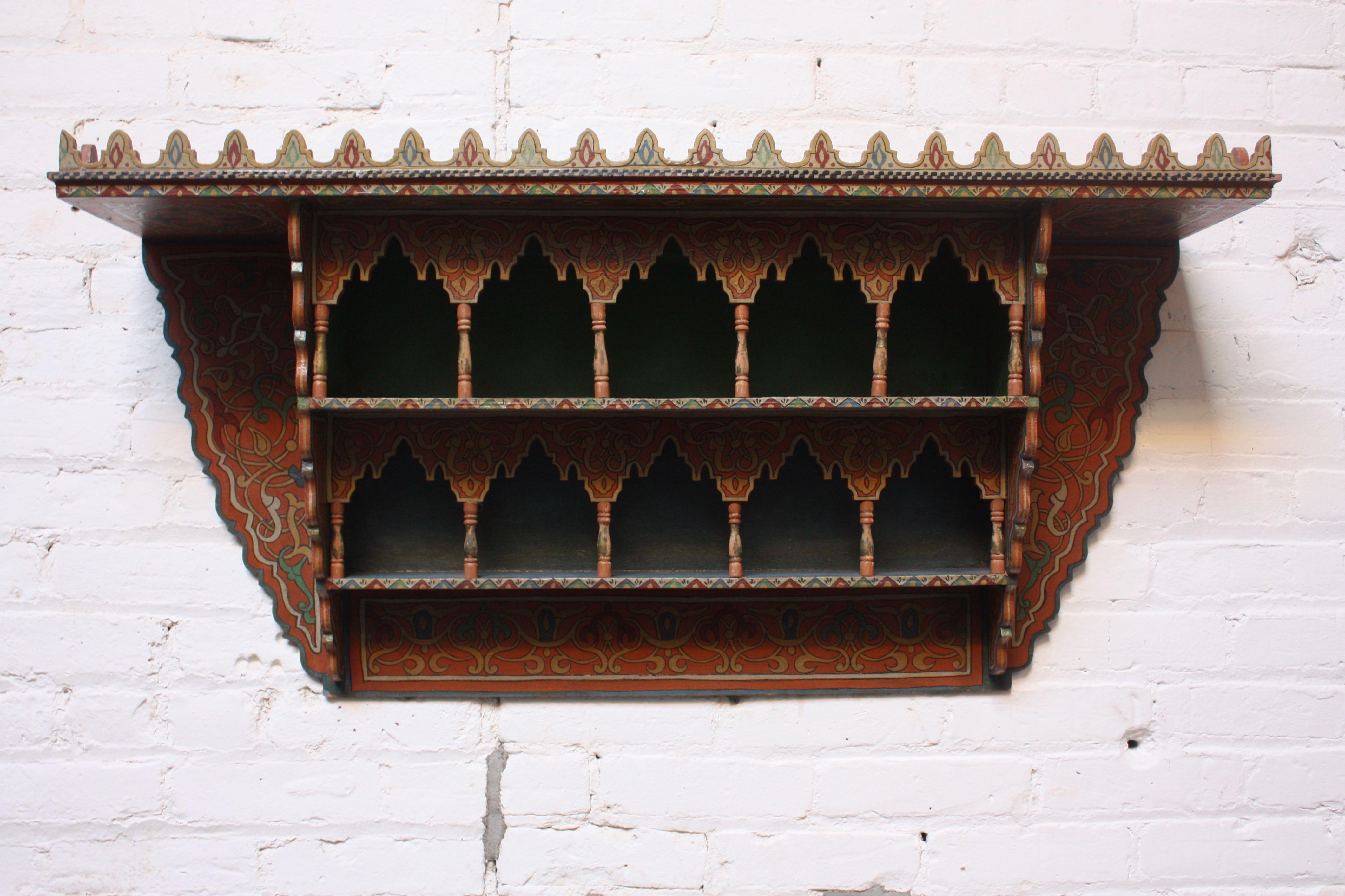 Whimsical Folk Art shelf (circa 1920s, USA) featuring carved and hand painted decoration. There are three tiers for storage in sky blue, green, and blue with carved and painted 'columns' adorning the two lower shelves. Given the restriction imposed