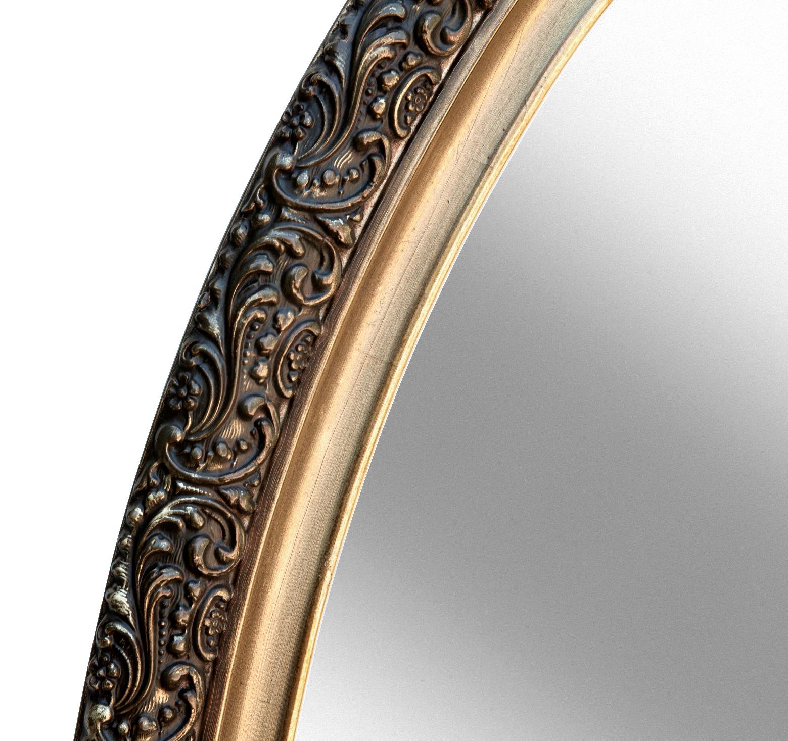 1940's Hollywood Recency style elongated mirror with gilt accents.
The darker tone enhances the ornate gilt accented broad border. 
Inner frame has a brighter edge around the darker convex antiqued channel.
Can be hung horizontally or vertically.

 