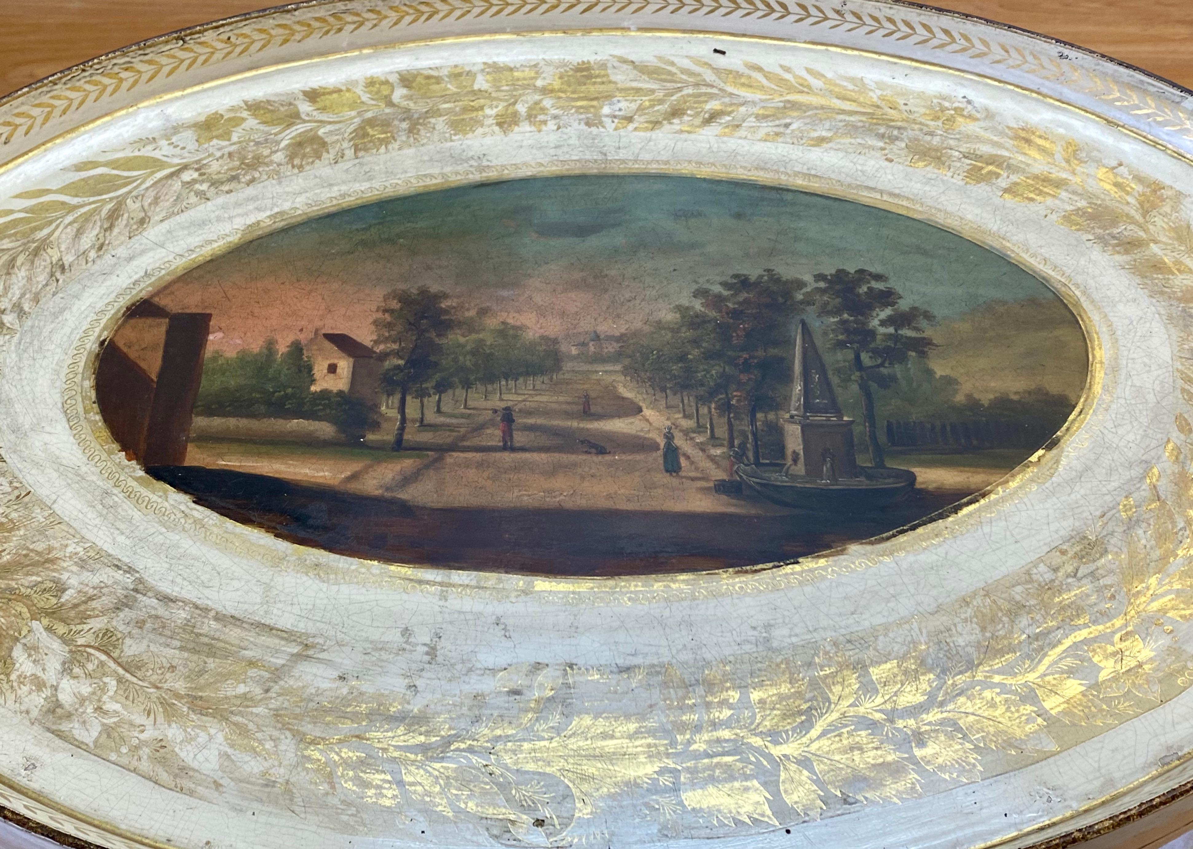 Hand painted european garden scene on metal tray on stand with glass insert, circa 1940.

A beautiful hand painted scene with ample remains of the gilded wreath surrounding the tray

A glass insert is included

The tray is
