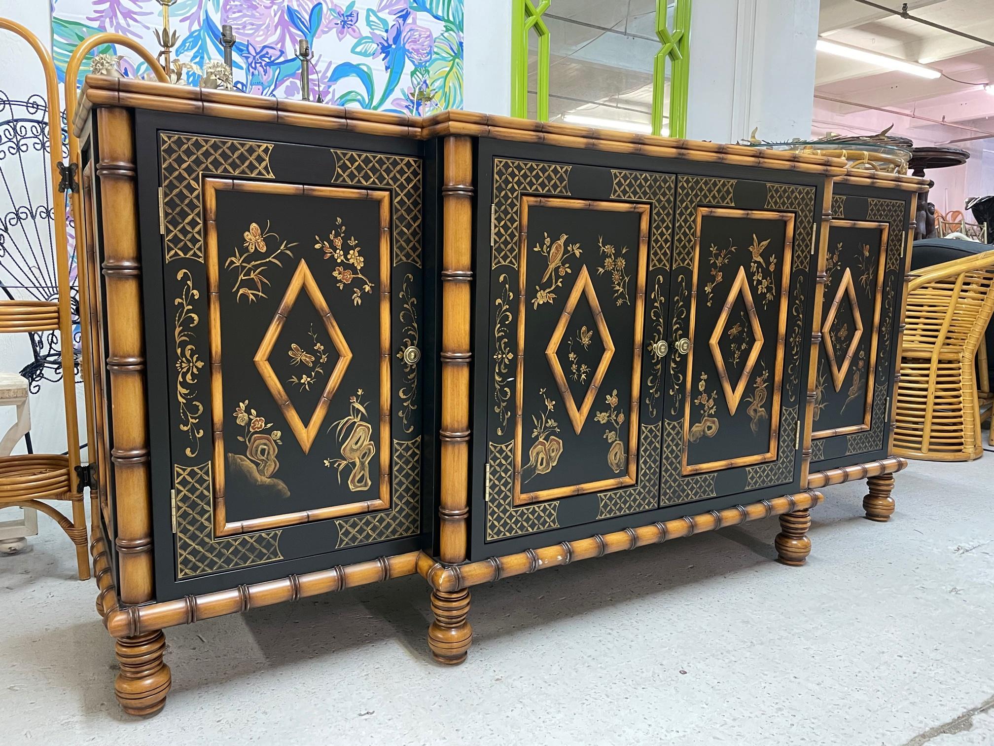 Large solid wood breakfront buffet/credenza feature faux bamboo detailing and hand painted doors. Three large storage areas with center shelf in each. Very good condition with only minor imperfections consistent with age.
 