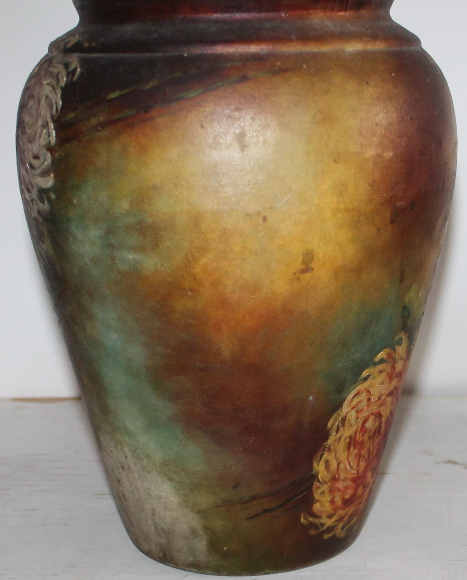 Ce vase Bauer en poterie peint à la main est un vase en argile rouge. Ce vase peint à la main avec des fleurs est en bon état.