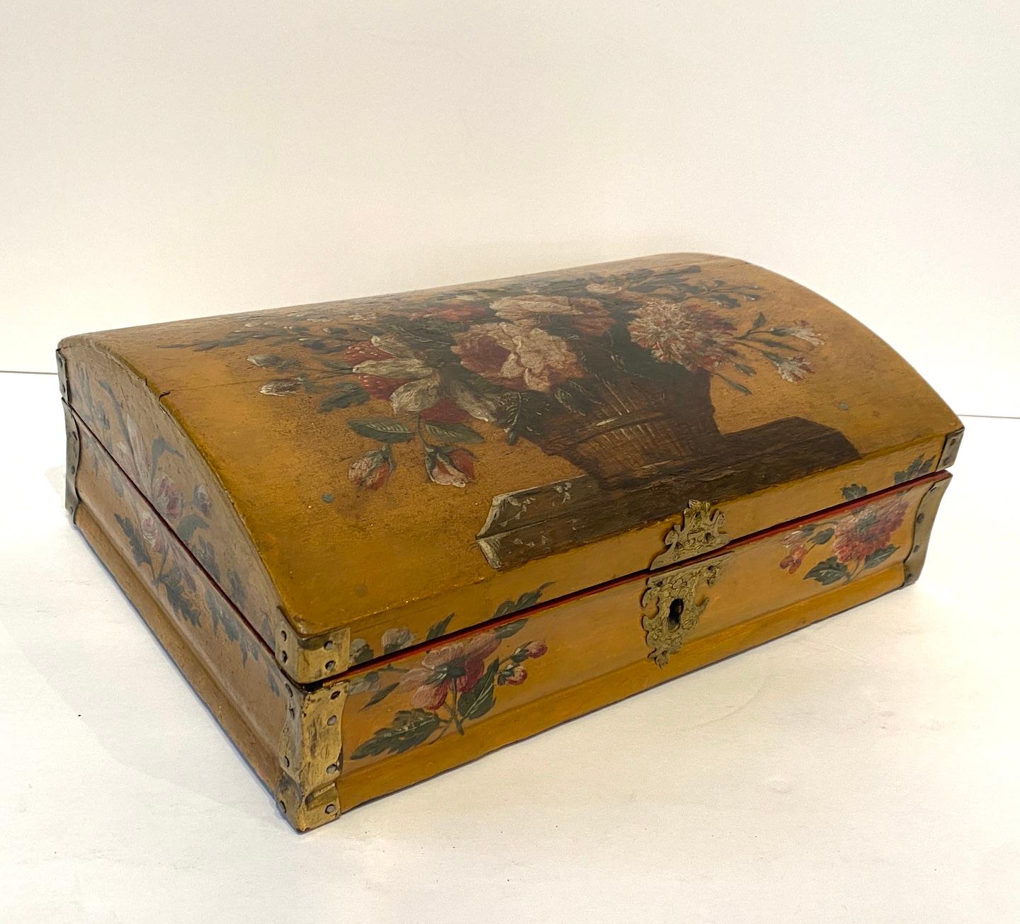 A beautiful hand painted, domed shape wig box with brass corners and incised brass surround around lock. Painted interior.