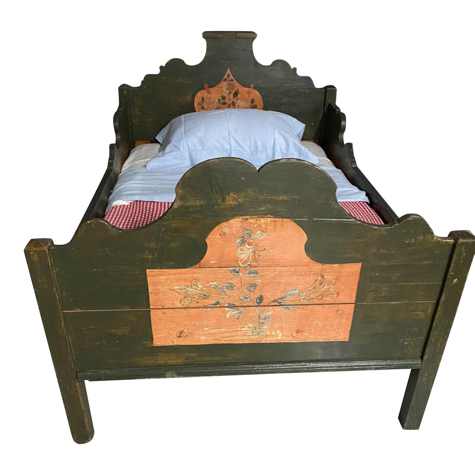 Single bed hand painted in olive green with pink floral motifs on the head and footboards

70 depth x 46.5 W

(23 Height of Side Rail) (43 H of Headboard) (38 Height of Footboard).