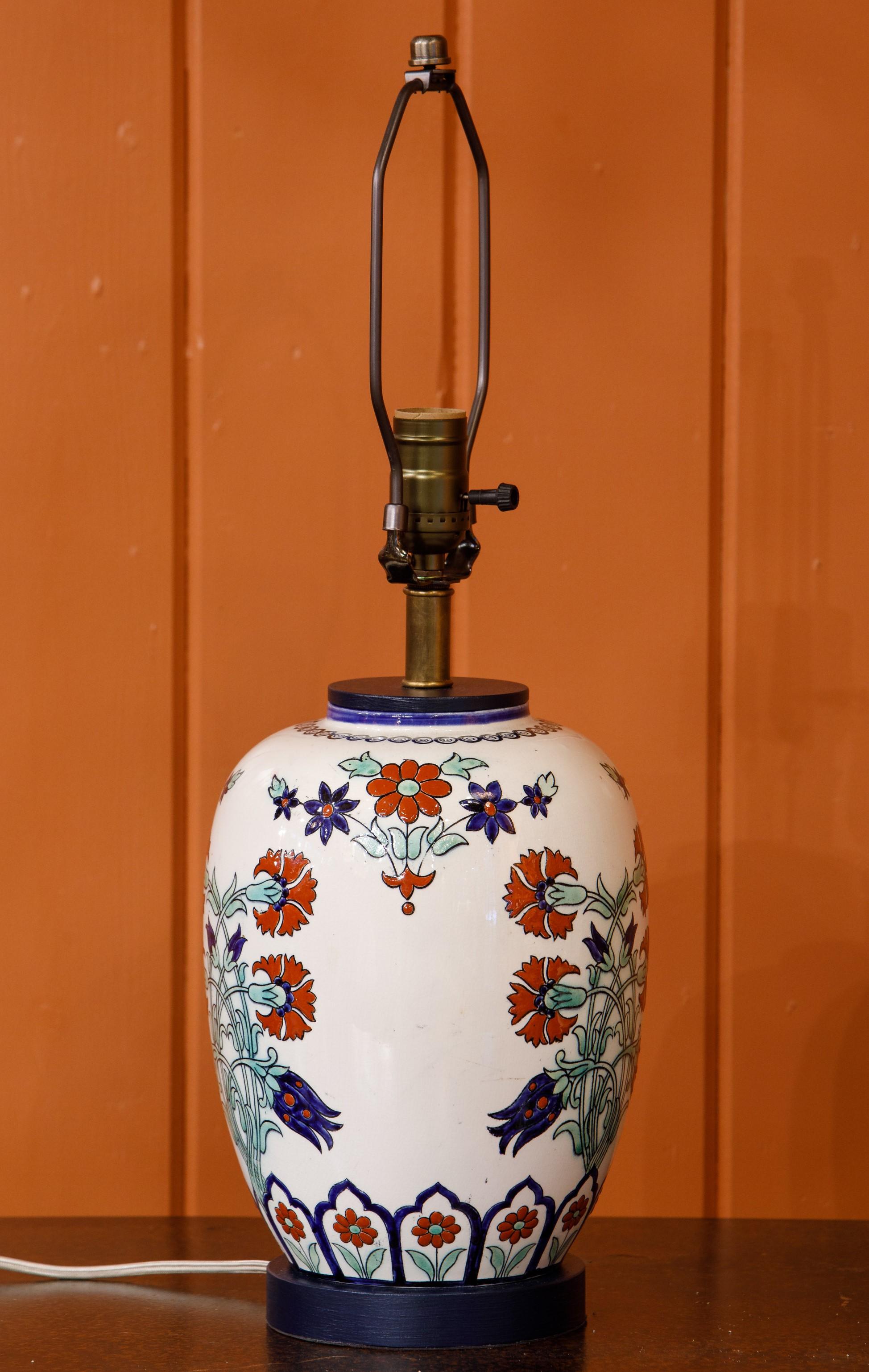This is an interesting lamp with a colorful, and unusual motif. The unusual pattern of the lamp has an Anglo-Indian feel with bold colors in a folky flower motif. The lamp is hand-crafted and hand-painted ceramic. It has been re-wired for the US