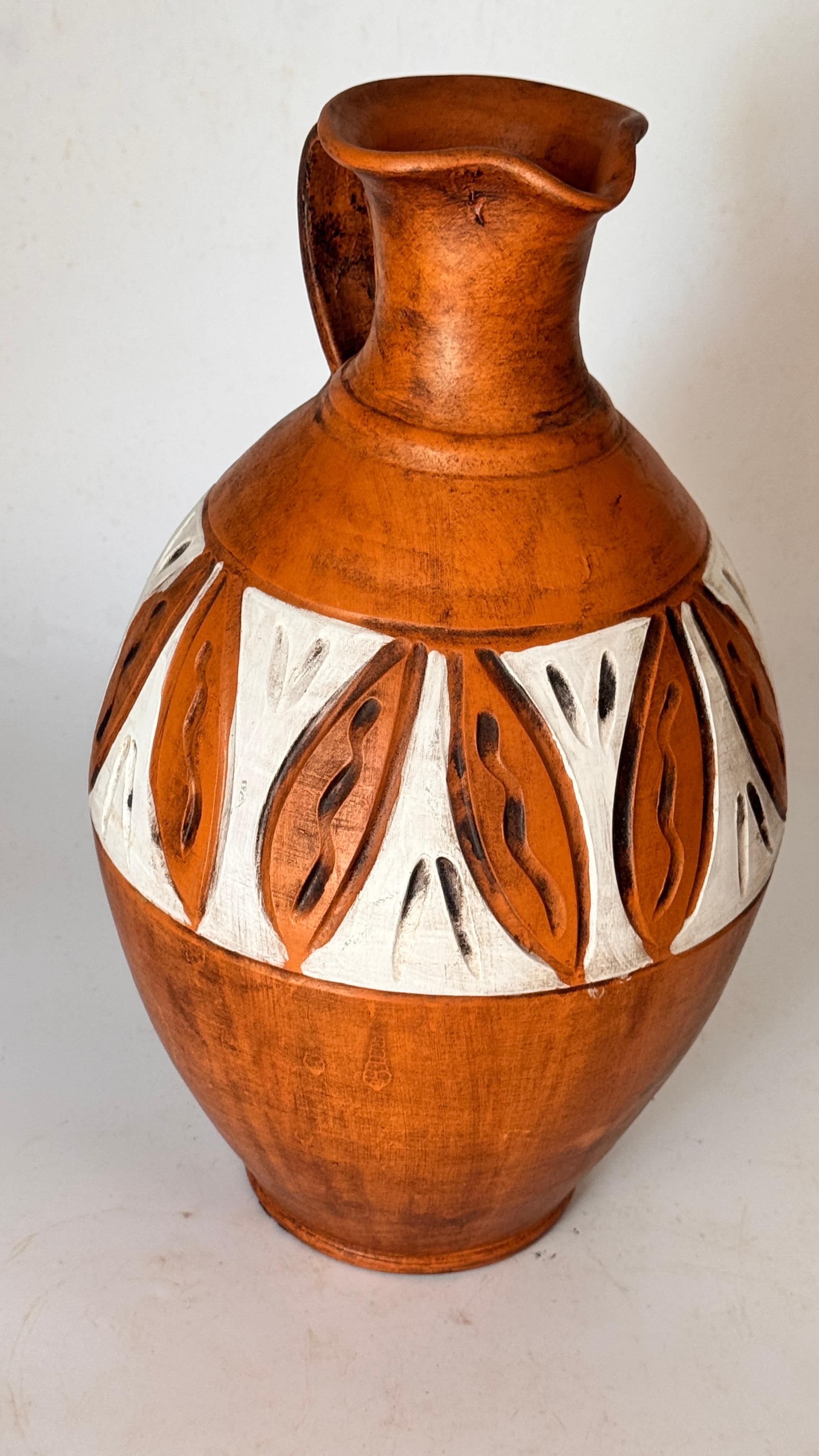 Hand-Painted French Ceramic Jug – Tribal Geometric Motifs – 20th Century

Description:
This is a ceramic jug made in France during the 20th century, featuring a rich brown patina and white hand-painted geometric decorations in a tribal-inspired