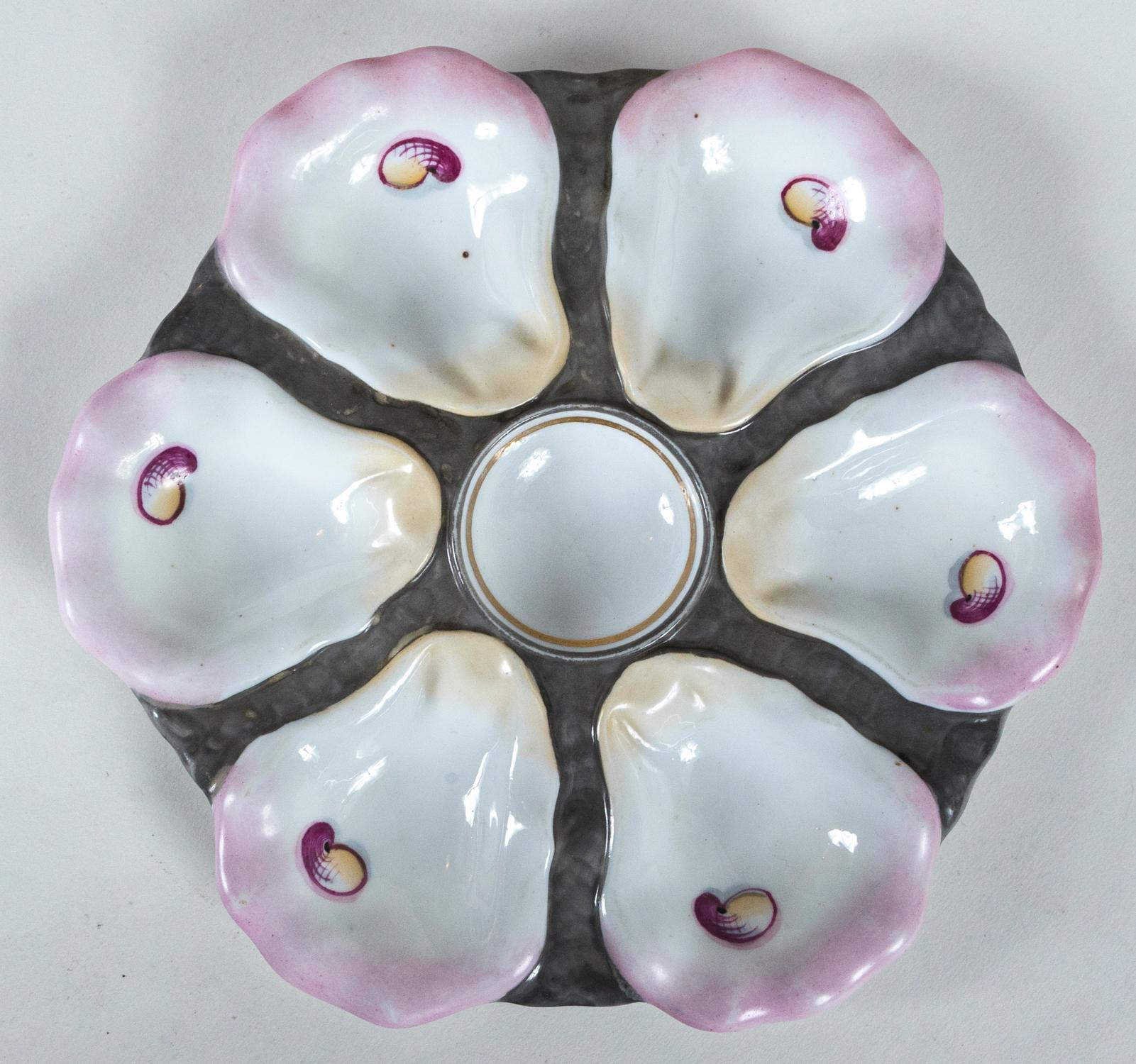 Hand-painted French Oyster plate, circa 1900. Six well plate. Pale pink accents with gray background. Marks on back: incised '143', signed '76'.