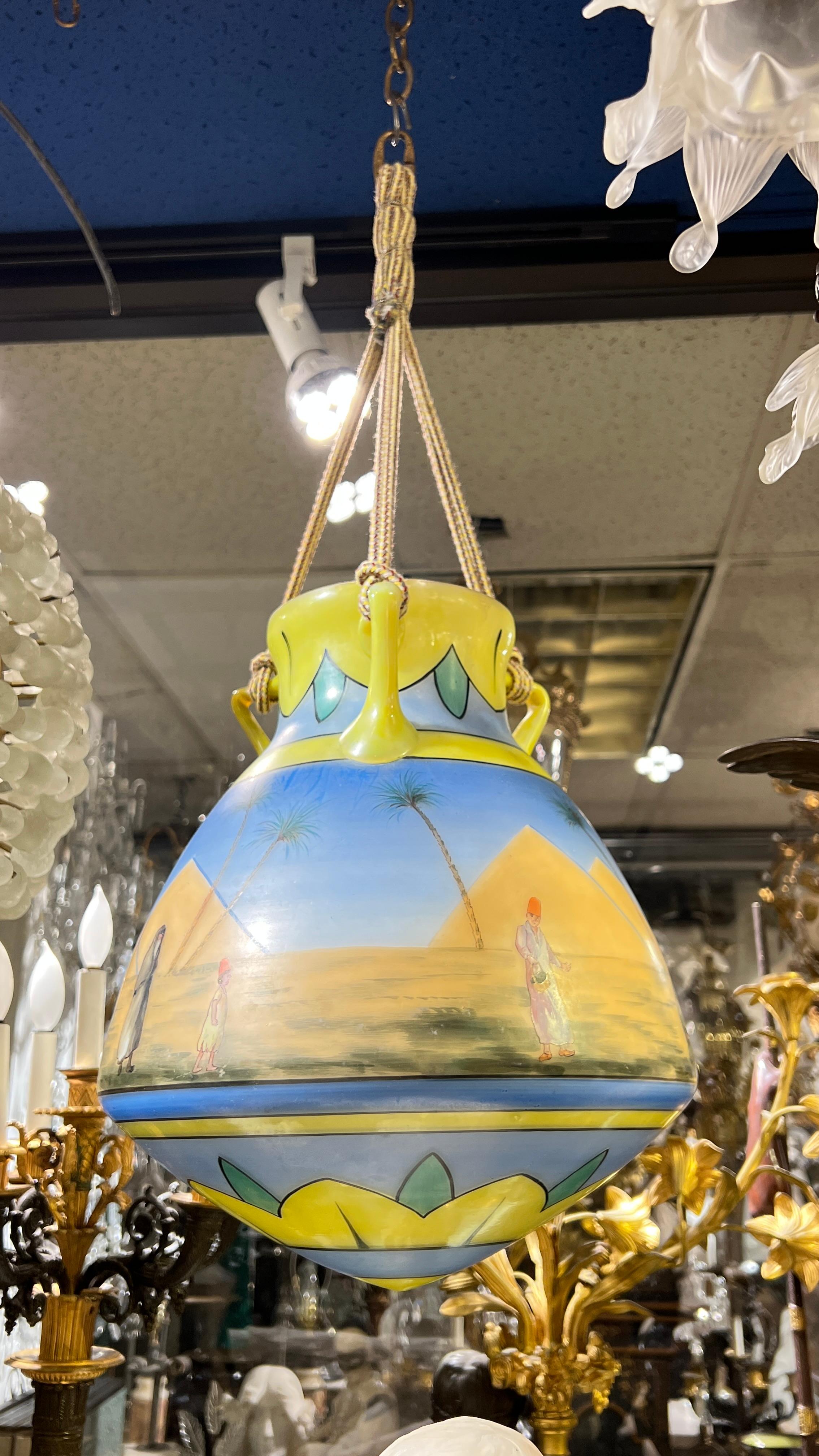 Glass mosque lamp with hand-painted scenes of various Egyptian figures on the Giza Plateau with the Great Pyramids in the background.  12 1/2 by 11 inches and 24.5 inches including its decorative hanging rope and hook.