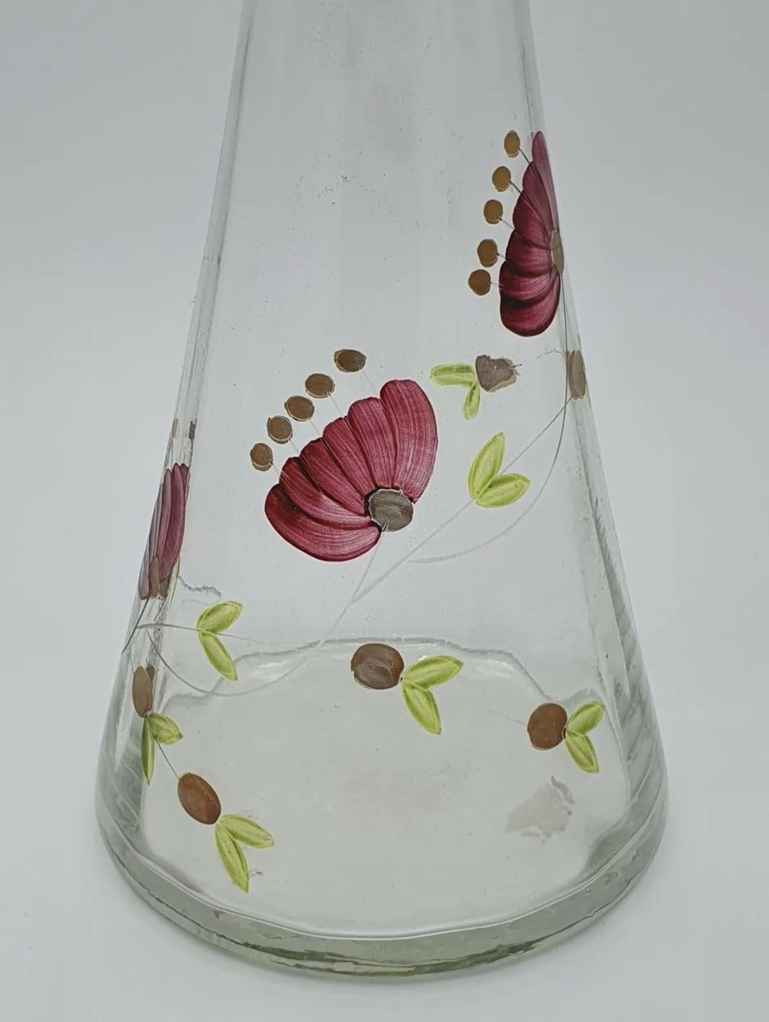 Caraffa degli anni '70 in vetro dipinto a mano con decorazioni floreali e tappo.
Particolare e scenografico per essere collocato all'interno di una vetrina o su una mensola della stanza.
Diametro della base 12 cm.
