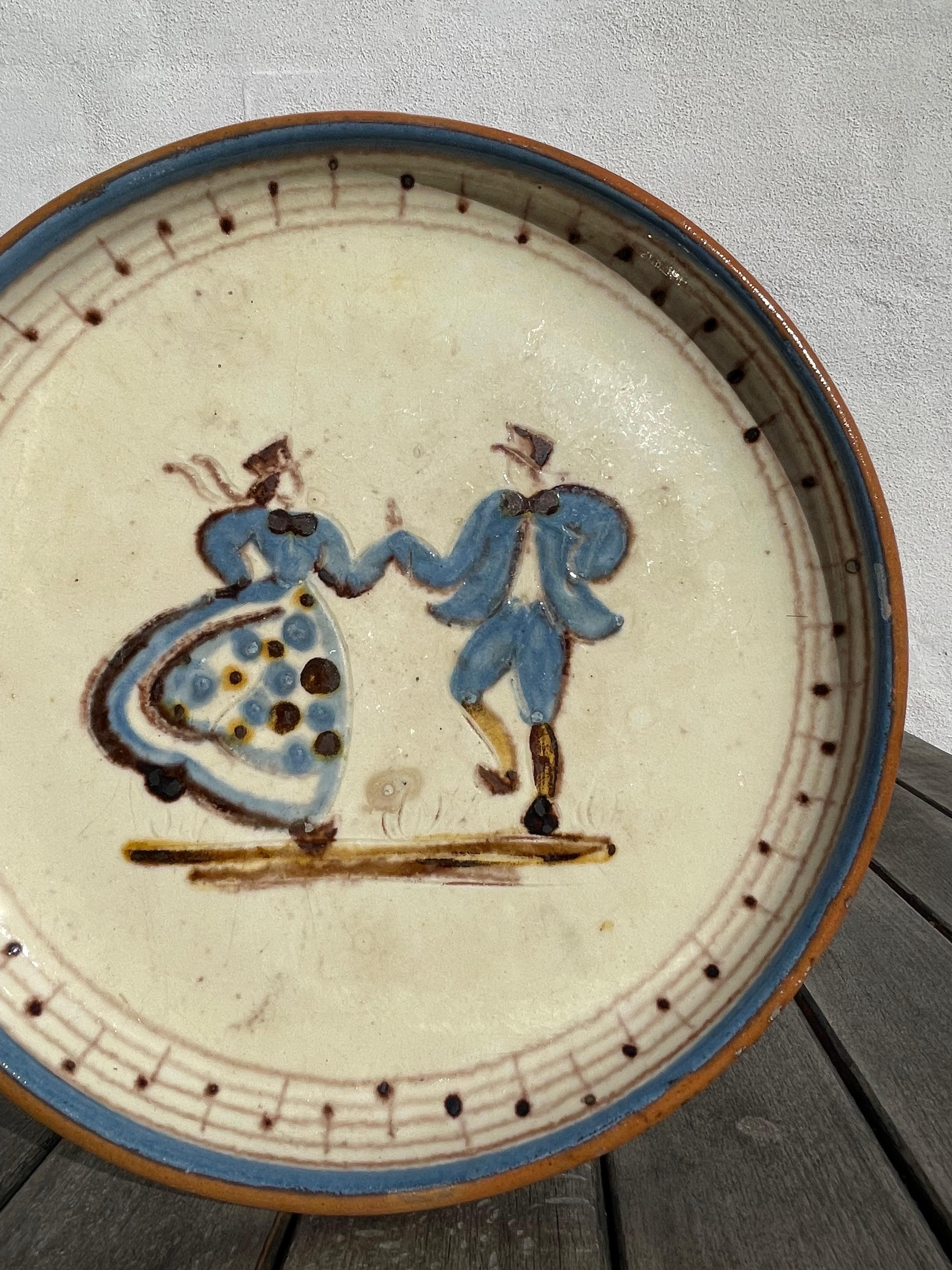 Danish modern 1950s ceramic decorative plate / dish / wall plaque by Knabstrup Keramik. Hand-painted decoration of two people in blue dancing on cream colored base. Great vintage condition. 
Denmark, 1950s.