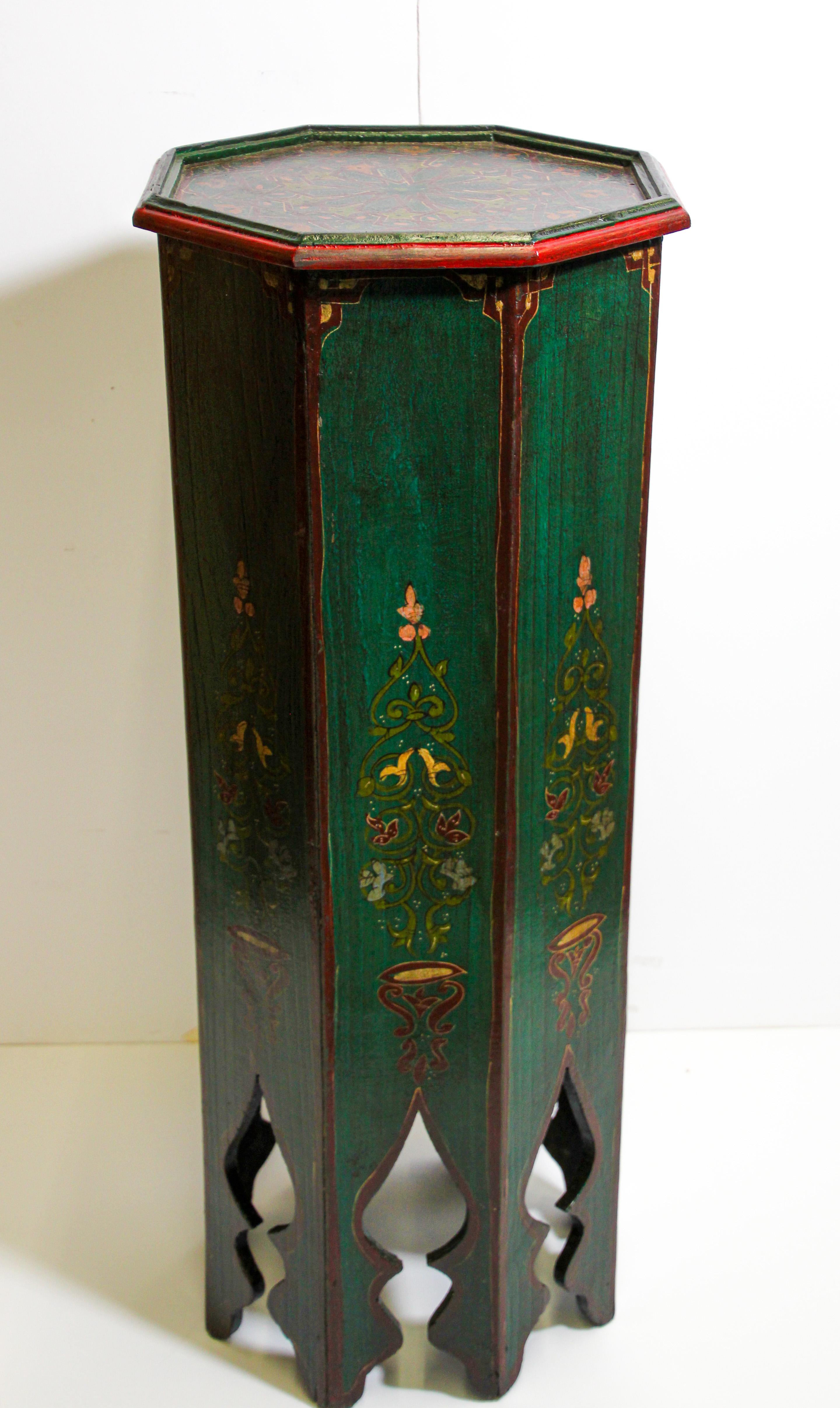 Moroccan vintage pedestal table, hand painted on a dark green background color with floral and geometric designs in red and yellow colors.
Moroccan handcrafted green pedestal table with Moorish red designs and cutout arches work on sides.
This