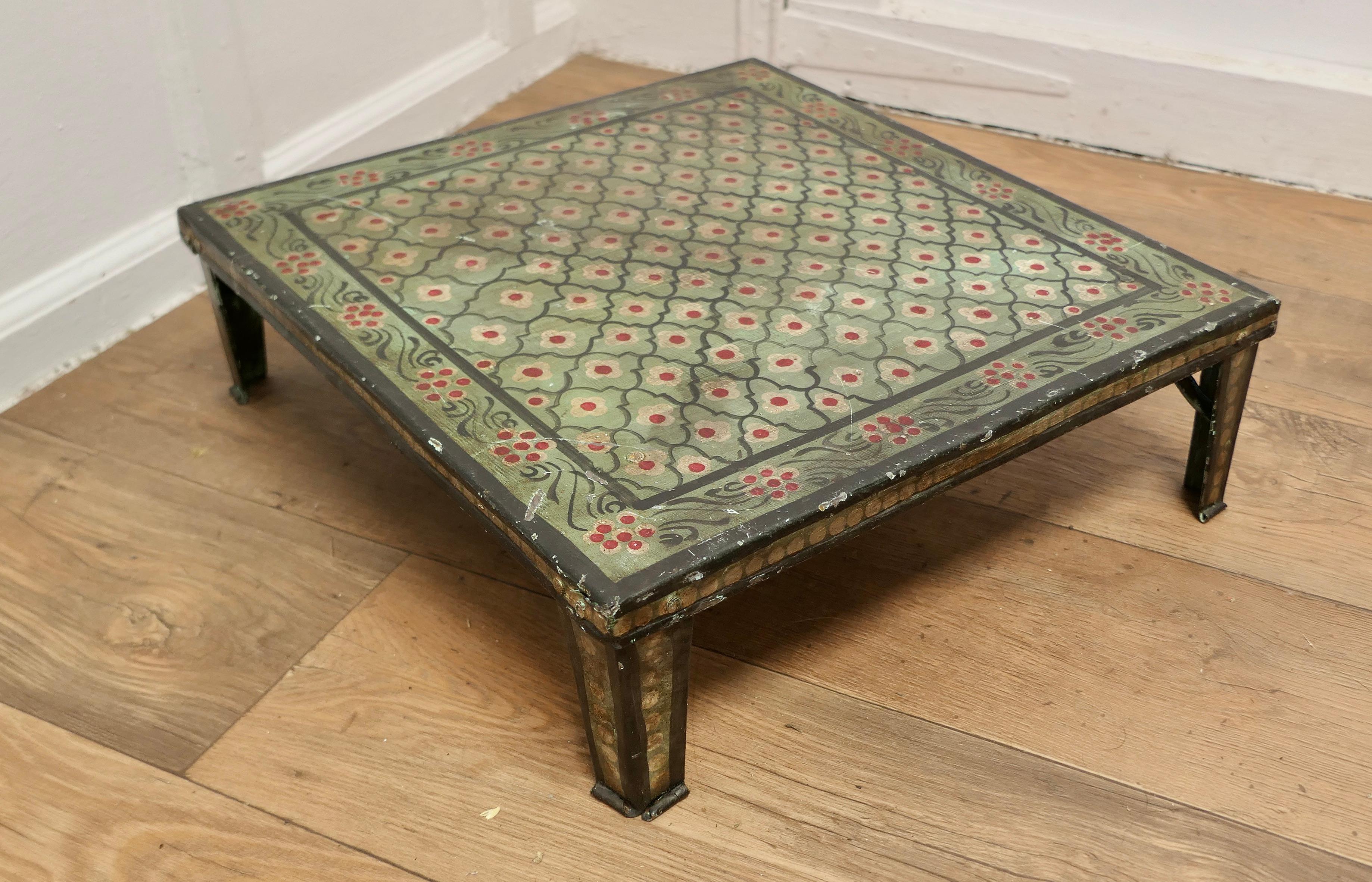 Hand Painted Indian Folk Art Stand or Low Table

A Lovely Decorative piece painted in a green pallet with small Flowers 
This little metal table is very stable if a little shabby 
The Stand is 6” high, and 20” square 
MS256