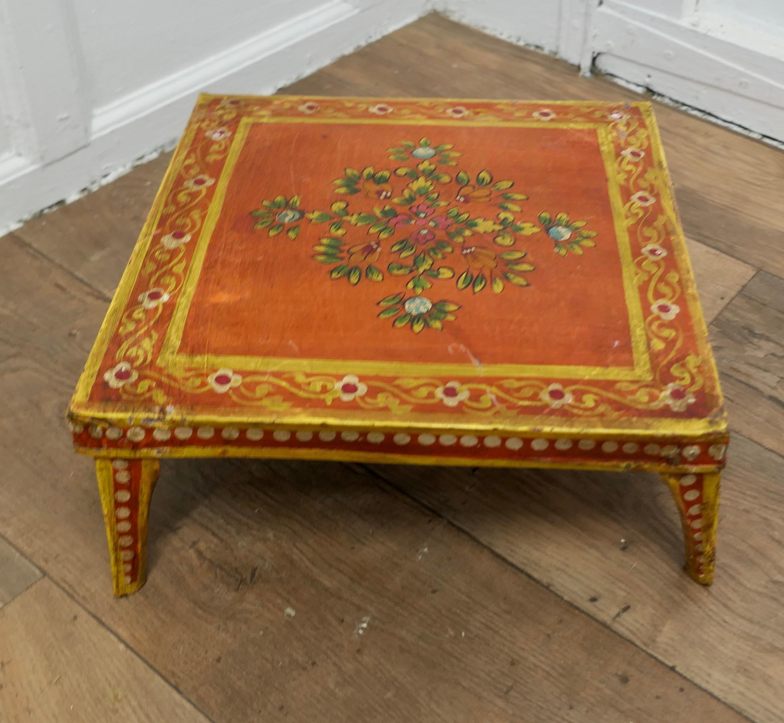 Hand Painted Indian Folk Art Stand or Low Table

A Lovely Decorative piece painted in an orange pallet with Flowers 
This little metal table is very stable if a little shabby 
The Stand is 6” high, and 15” square 
MS255