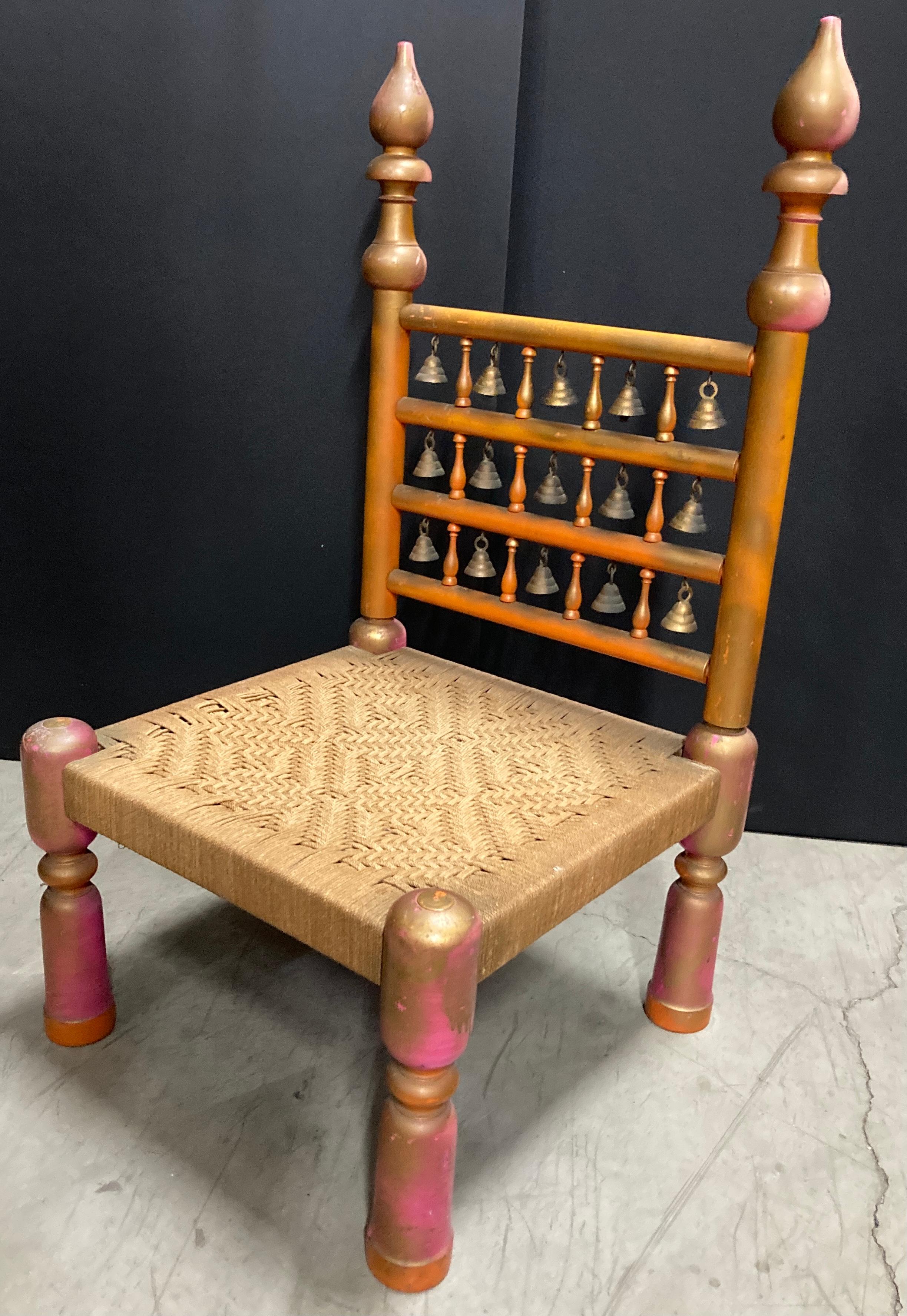 Indian Rajasthani low chair with handwoven seat.
An antique Indian Moorish rustic low wooden chair. 
Charming our eyes with its rustic appearance, this low wooden chair features a straight back. 
With its nicely weathered appearance and delicate