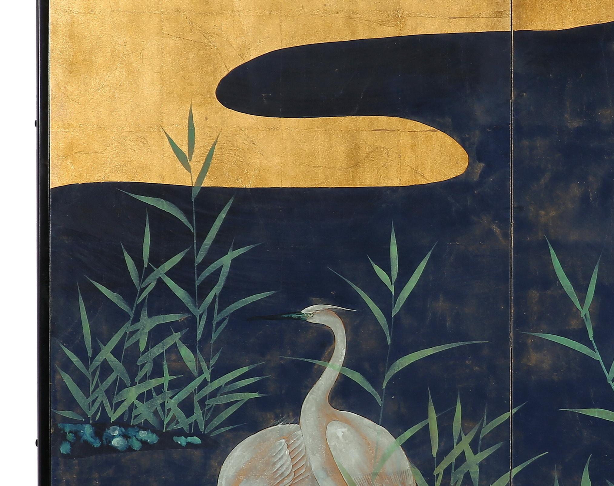 The cranes by the reeds painting of this two-panel screen is hand painted in watercolor, on squares of gold leaf which are applied by hand to the paper base over carefully jointed wooden lattice frames. Lacquer rails are then applied to the