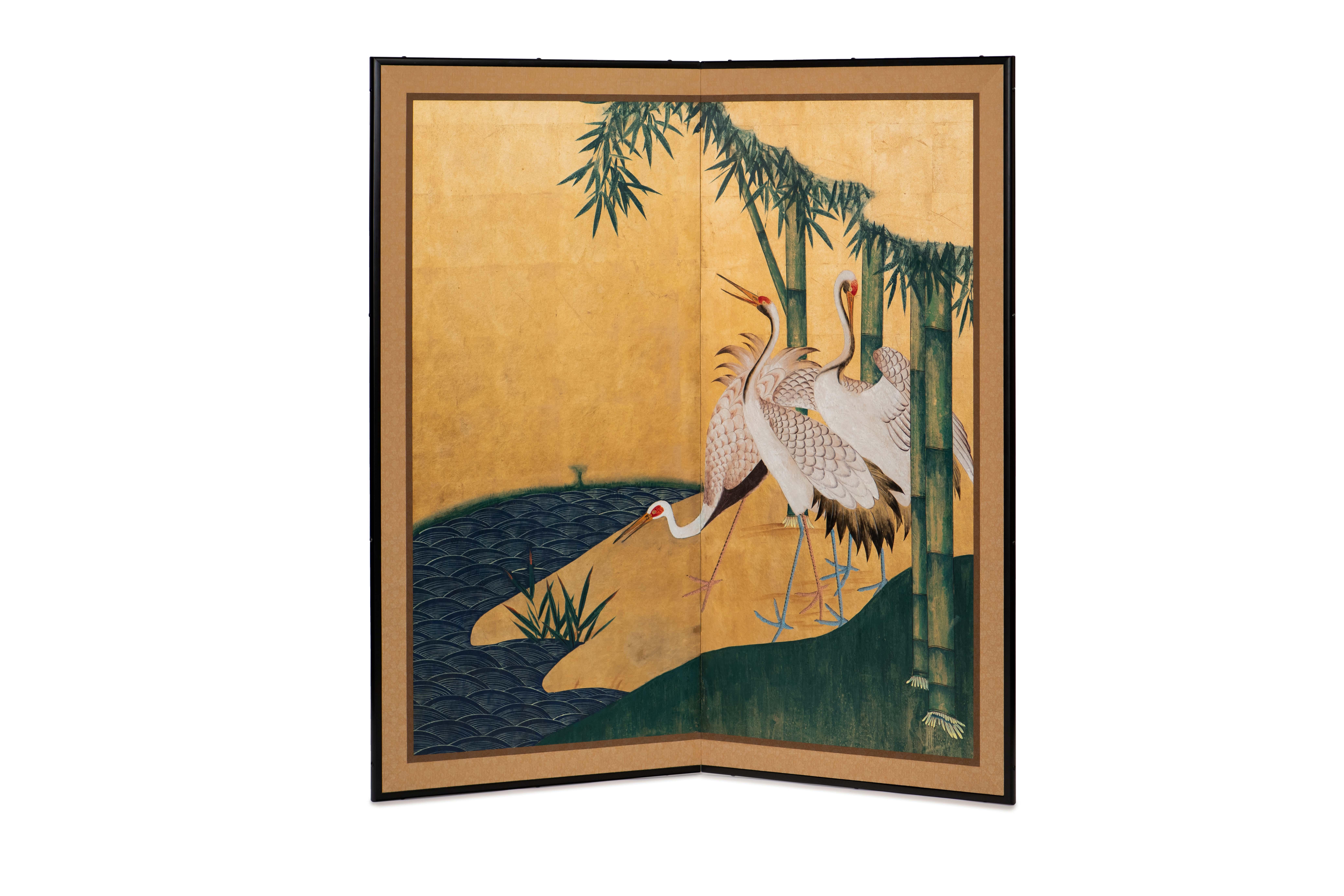 The cranes by the river painting of this two-panel screen is hand-painted in watercolor, on squares of gold leaf which are applied by hand to the paper base over carefully jointed wooden lattice frames. Lacquer wooden rails are then applied to the