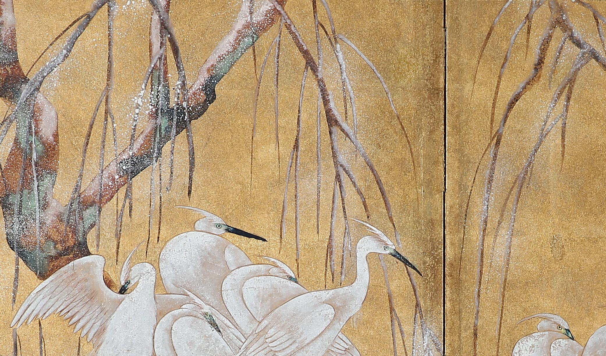 The egrets by the trees painting of this two-panel screen is hand-painted in watercolor, on squares of gold leaf which are applied by hand to the paper base over carefully jointed wooden lattice frames. Lacquer rails are then applied to the