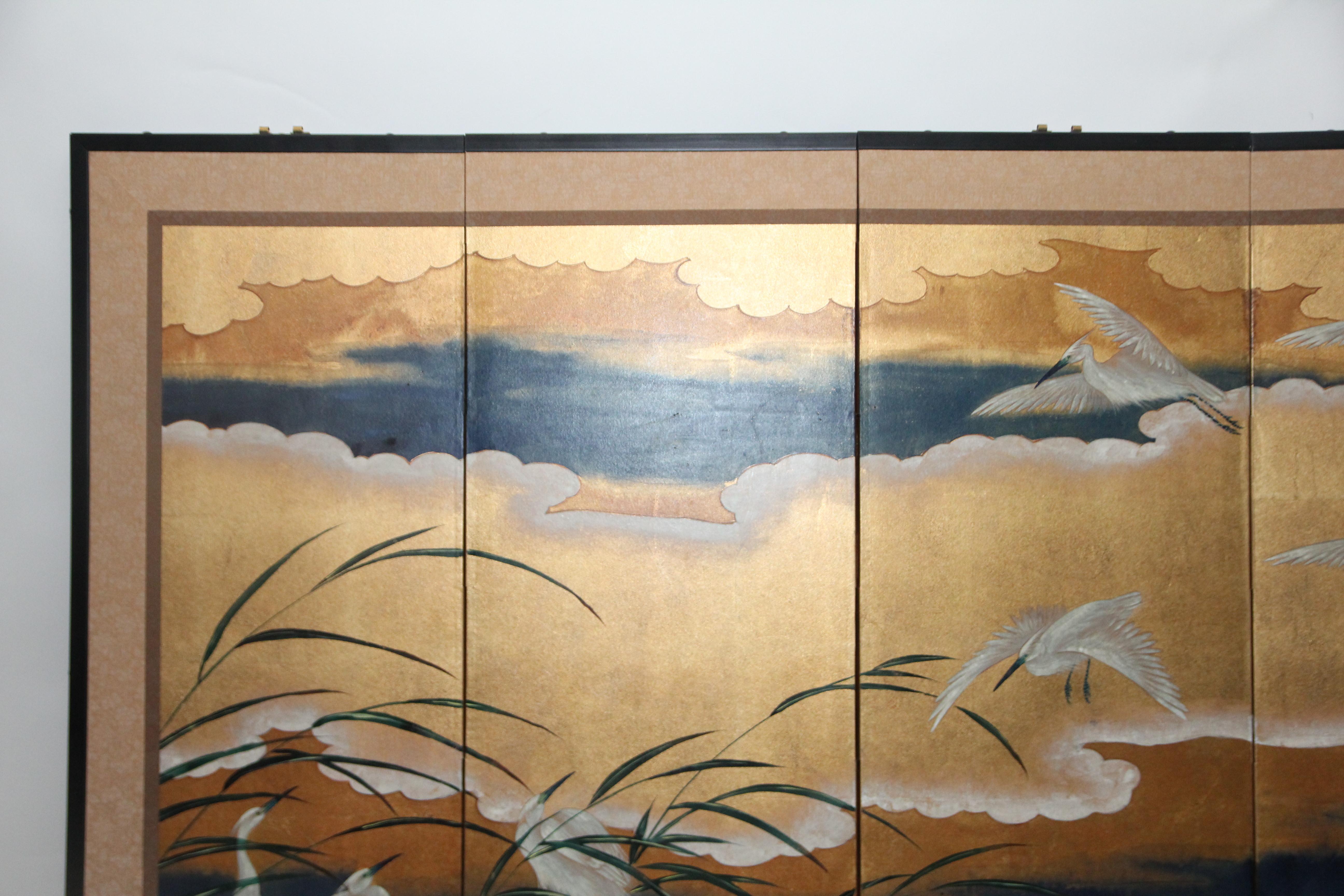 The flying cranes painting of this six-panel screen is hand-painted in watercolor, on squares of gold leaf which are applied by hand to the paper base over carefully jointed wooden lattice frames. Lacquer rails are then applied to the perimeter to