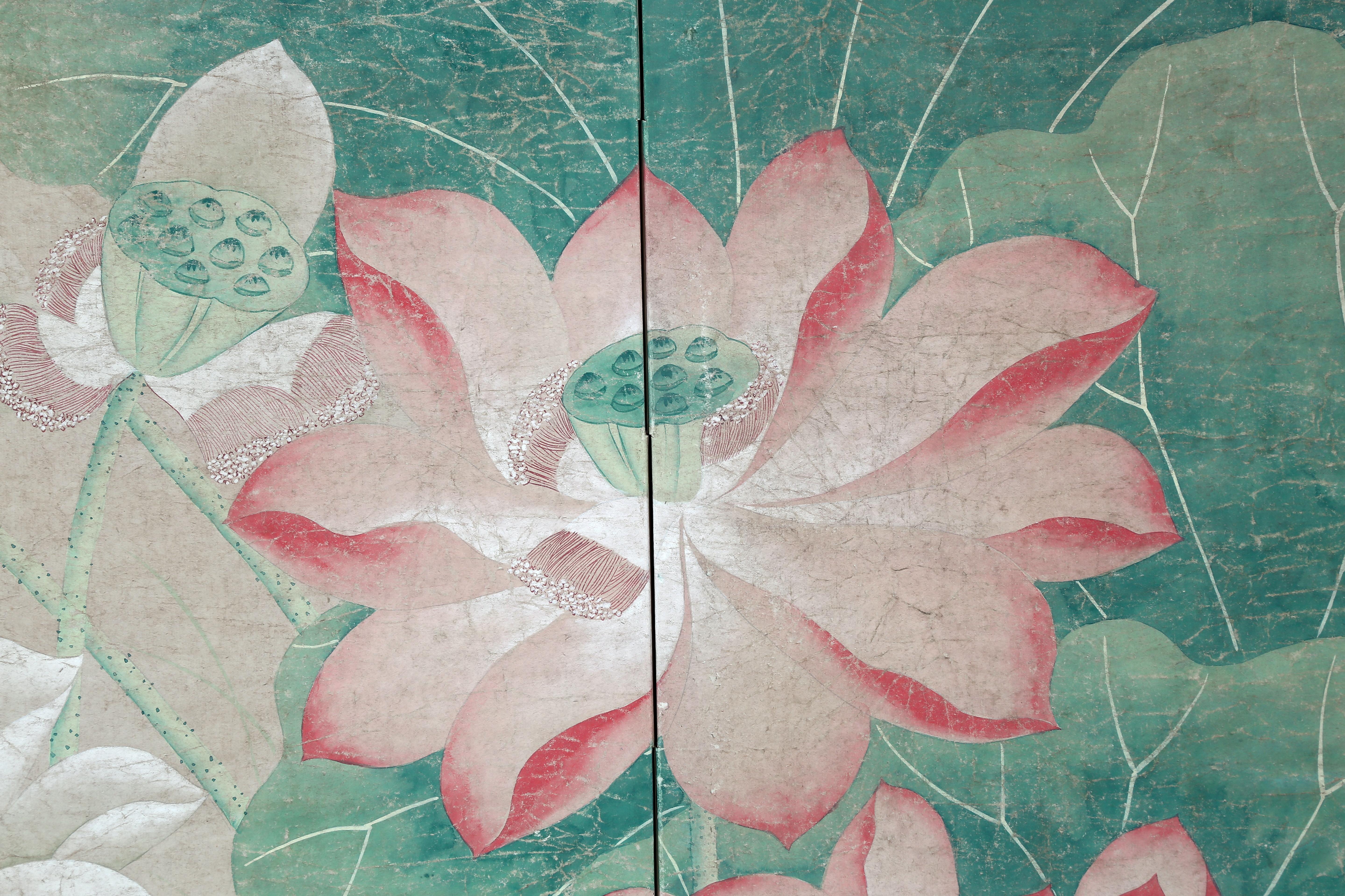 The lotus pond painting of this four-panel screen is hand painted in watercolor, on the paper base over carefully jointed wooden lattice frames. Lacquer rails are then applied to the perimeter to finish the edges of the screen and provide support.
