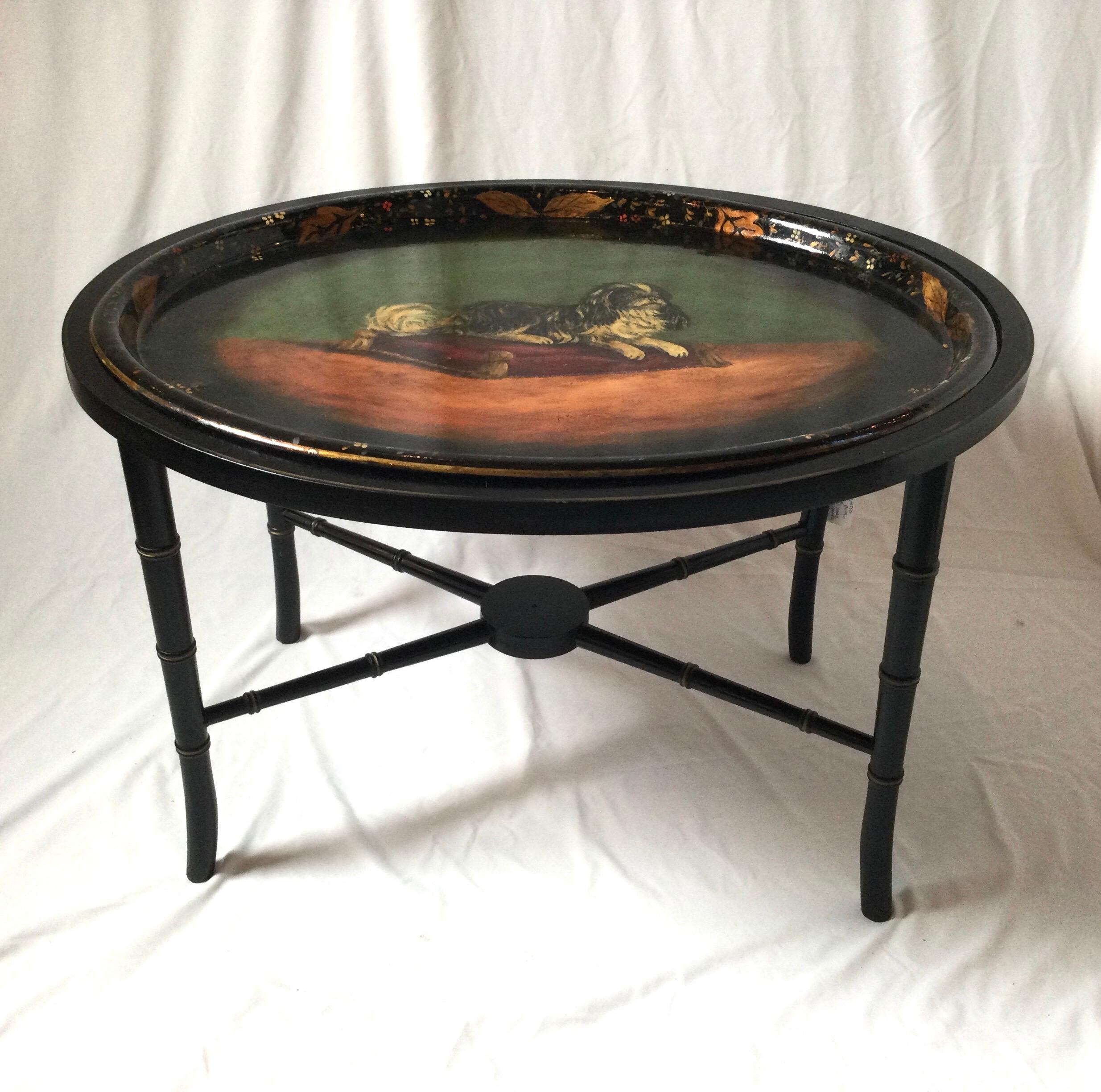 Hand painted King Charles Spaniel tray cocktail table with faux bamboo fitted base. Floral design around edges of tray. Some minor wear to gold around edges and perimeter of table. Oval table measures 30 by 24