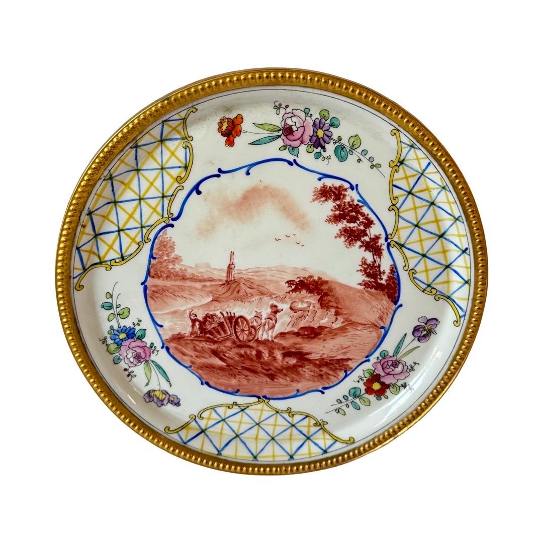 A beautifully hand-painted porcelain plate from Paul Lefèvre, Limoges, dating to the late 19th century (circa 1880–1900). Inspired by the Rococo revival style of the period, the plate features a finely executed sepia pastoral scene (camaïeu bistre),