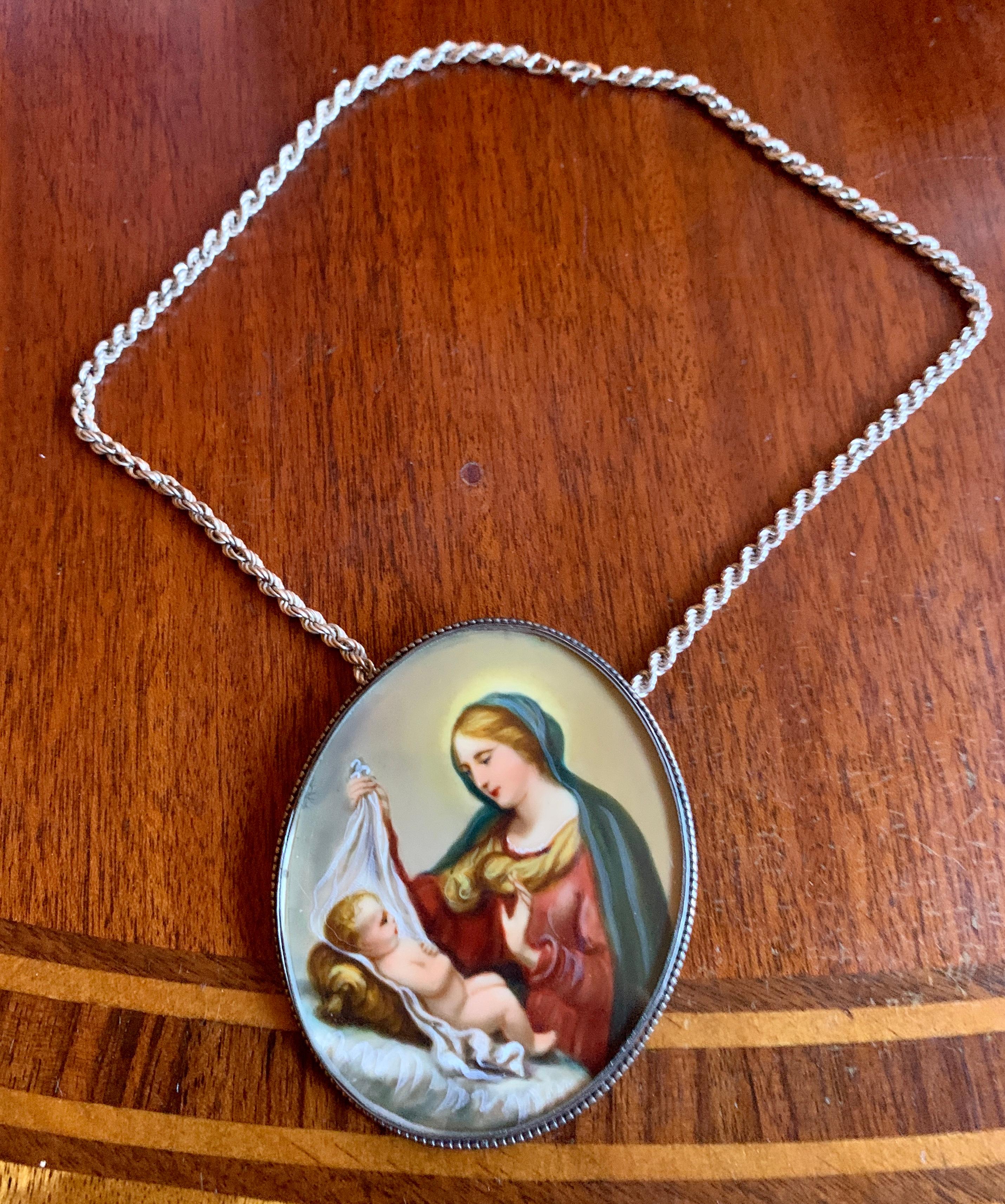 This is a wonderful Antique Pendant Necklace with an extraordinary hand painted portrait miniature of the Madonna and Child in a Sterling Silver Frame and Sterling Silver chain.  The portrait miniature is of the highest quality.  The faces of the