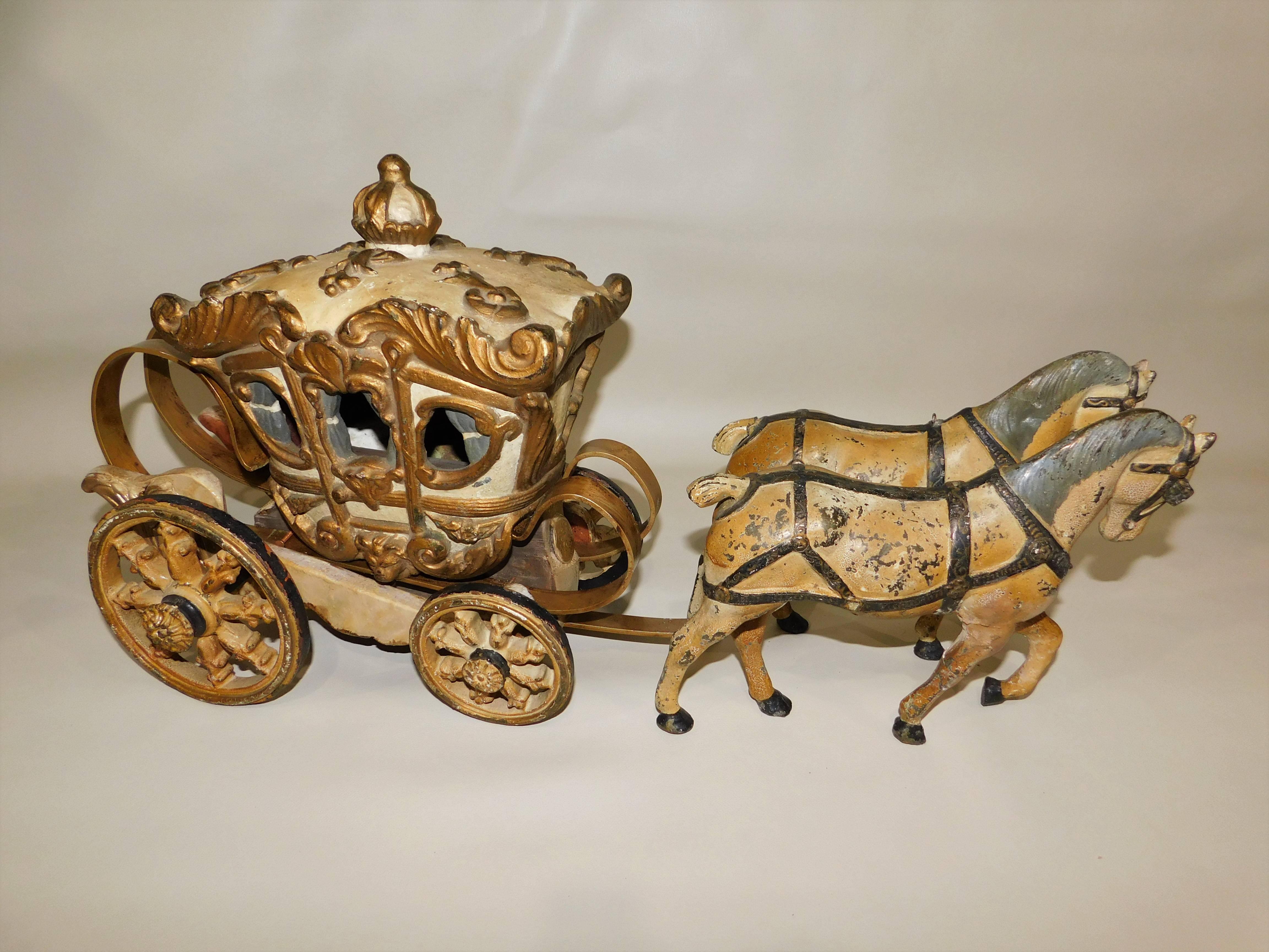 Hand-painted metal and wood horses pulling an ornate carriage. Was used as an advertising window prop or just as a toy.